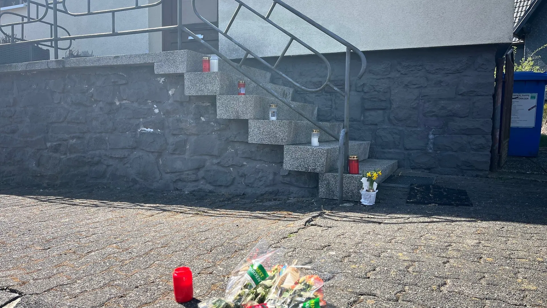 Blumen und Kerzen am Haus der ermordeten Familie in Weitefeld