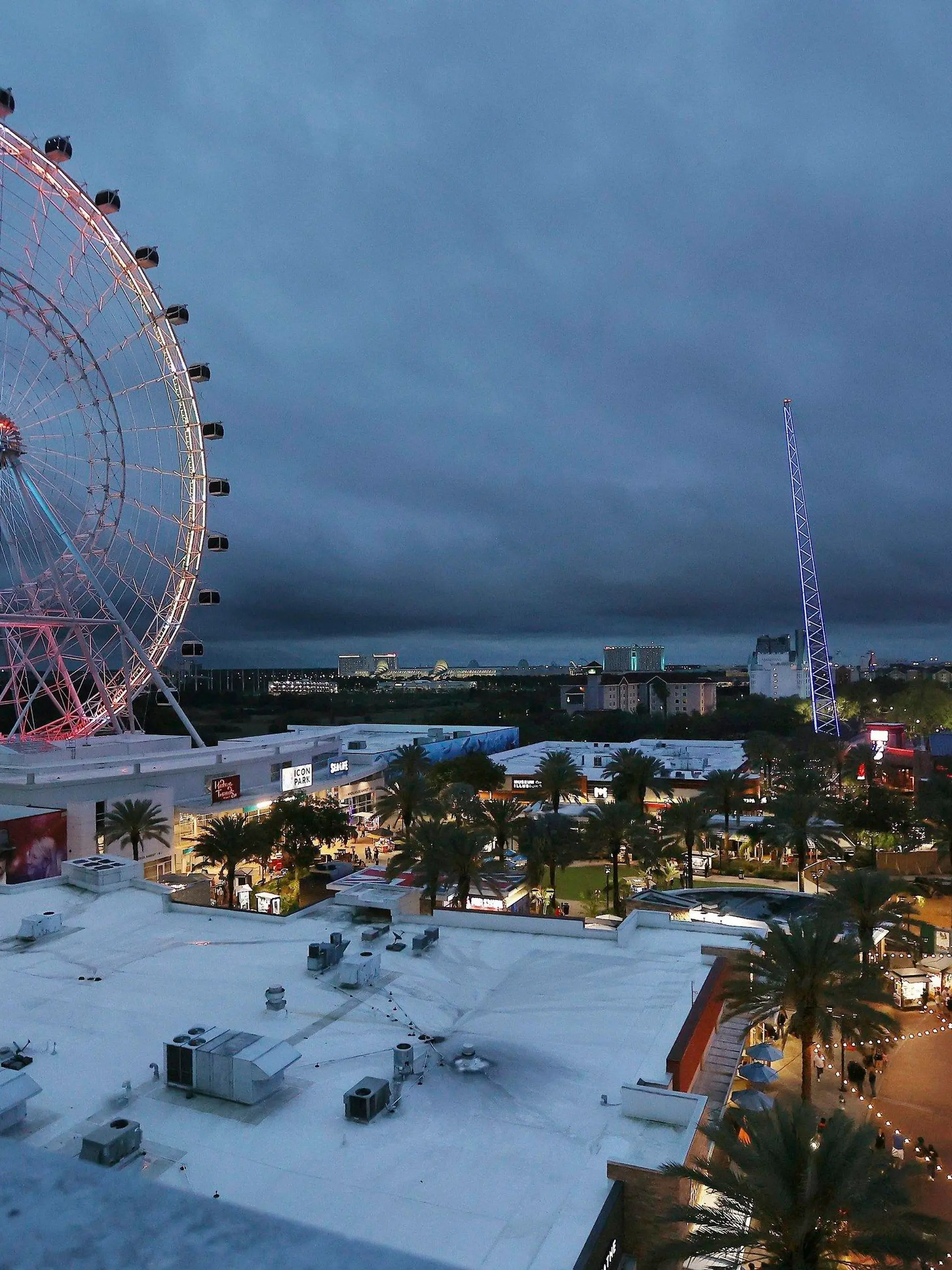 ICON Park attractions, The Wheel, left, Orlando SlingShot, middle, and Orlando FreeFall, right, are shown in Orlando, Fla., on Thursday, March 24, 2022.   A 14-year-old boy fell to his death from a ride at an amusement park in Orlando, sheriff's officials said. Sheriff's officials and emergency crews responded to a call late Thursday at Icon Park, which is located in the city's tourist district along International Drive. The boy fell from the Orlando Free Fall ride, which opened late last year.(Stephen M. Dowell /Orlando Sentinel via AP)