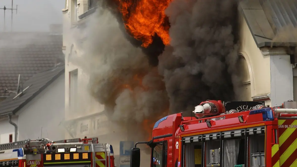 18.06.2023, Nordrhein-Westfalen, St. Augustin: Flammen schlagen aus einem Dach. Ein Motorradladen ist in Sankt Augustin im Rhein-Sieg-Kreis in Brand geraten. Zahlreiche Einsatzkräfte sind am Sonntag ausgerückt. Foto: Ralf Klodt/dpa +++ dpa-Bildfunk +++