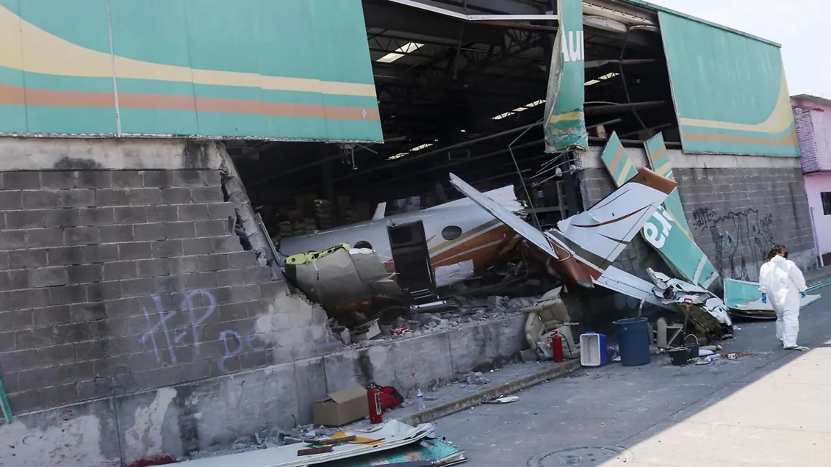 A forensic technician walks by the wreckage of a small plane that crashed into a supermarket, in Temixco, in Morelos state, Mexico March 28, 2022. REUTERS/Margarito Perez