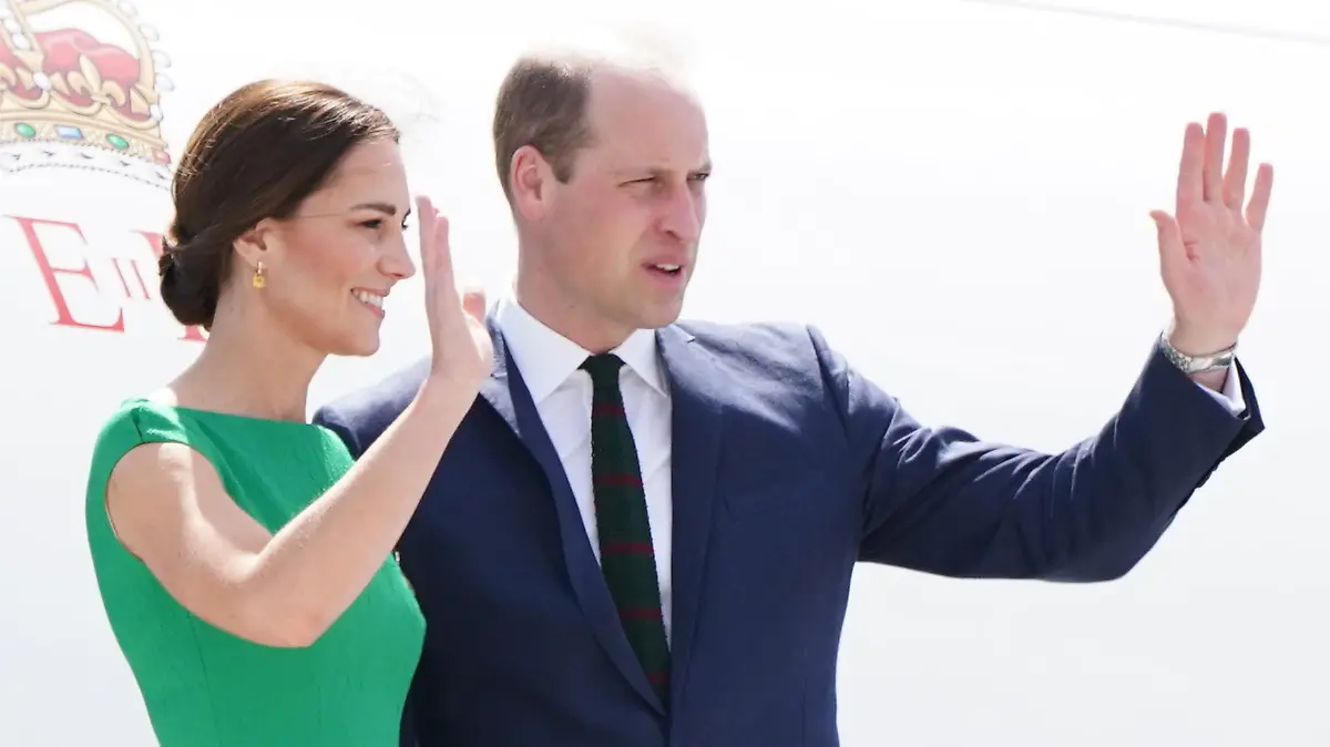 24.03.2022, Jamaika, Kingston: Prinz William, Herzog von Cambridge, und Kate, Herzogin von Cambridge, winken auf den Stufen des Flugzeugs, bevor sie auf die Bahamas fliegen. William und Kate reisen seit dem 19.03.2022 im Auftrag der Queen anlässlich deren 70. Thronjubiläums durch mehrere Länder Mittelamerikas und der Karibik. Foto: Jane Barlow/PA Wire/dpa +++ dpa-Bildfunk +++