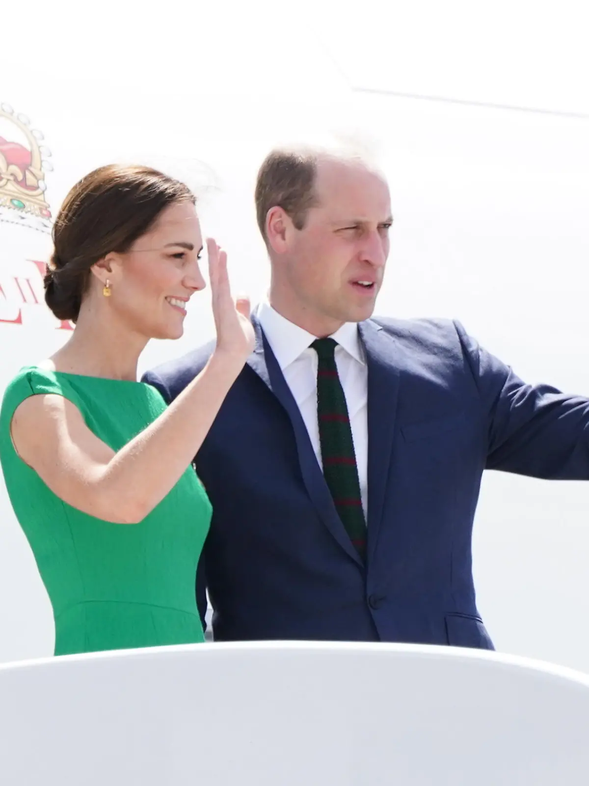 24.03.2022, Jamaika, Kingston: Prinz William, Herzog von Cambridge, und Kate, Herzogin von Cambridge, winken auf den Stufen des Flugzeugs, bevor sie auf die Bahamas fliegen. William und Kate reisen seit dem 19.03.2022 im Auftrag der Queen anlässlich deren 70. Thronjubiläums durch mehrere Länder Mittelamerikas und der Karibik. Foto: Jane Barlow/PA Wire/dpa +++ dpa-Bildfunk +++