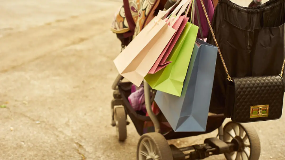 Outdoor crop shot of baby carriage with shopping bags. Copy space.