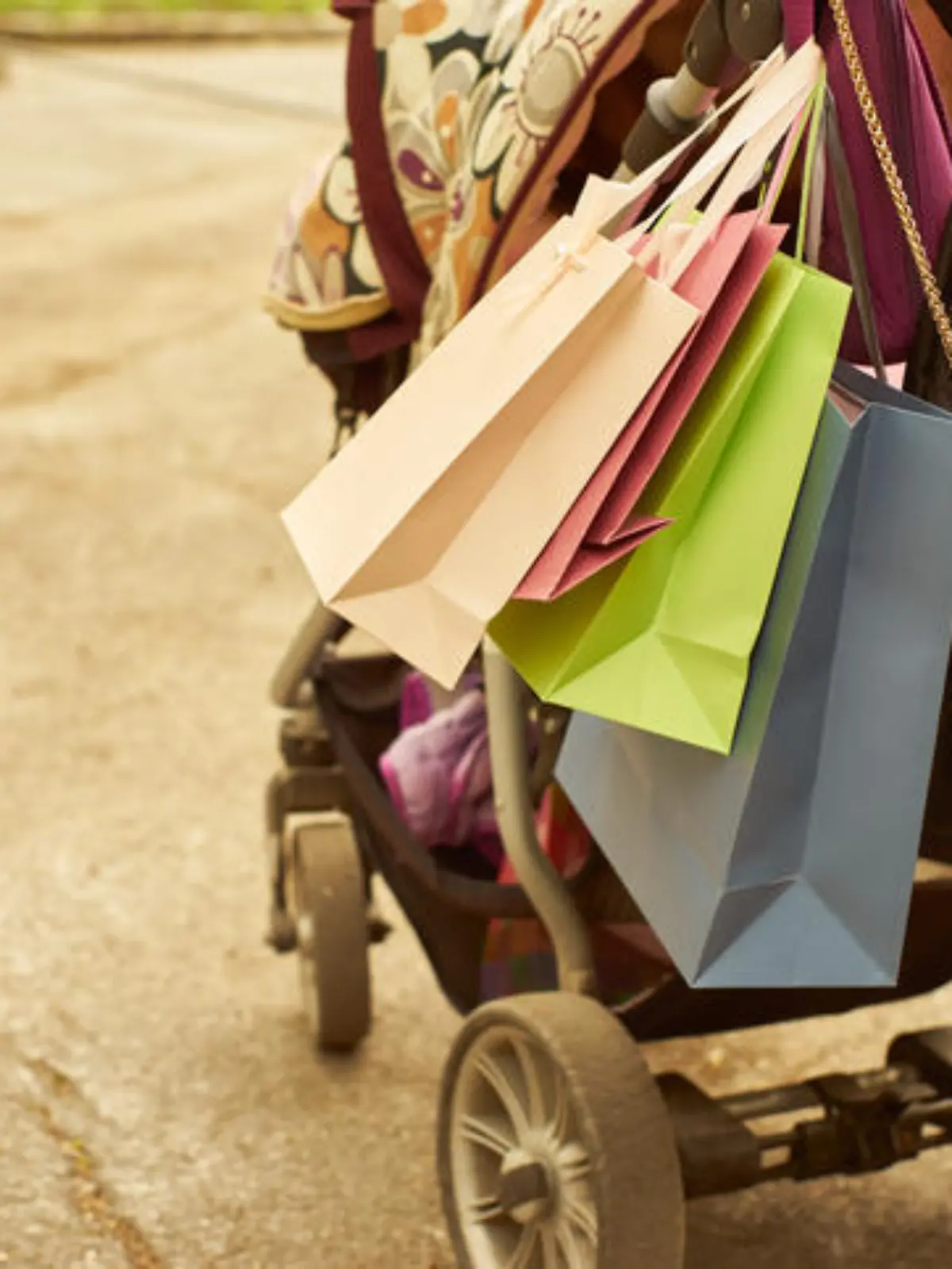 Outdoor crop shot of baby carriage with shopping bags. Copy space.