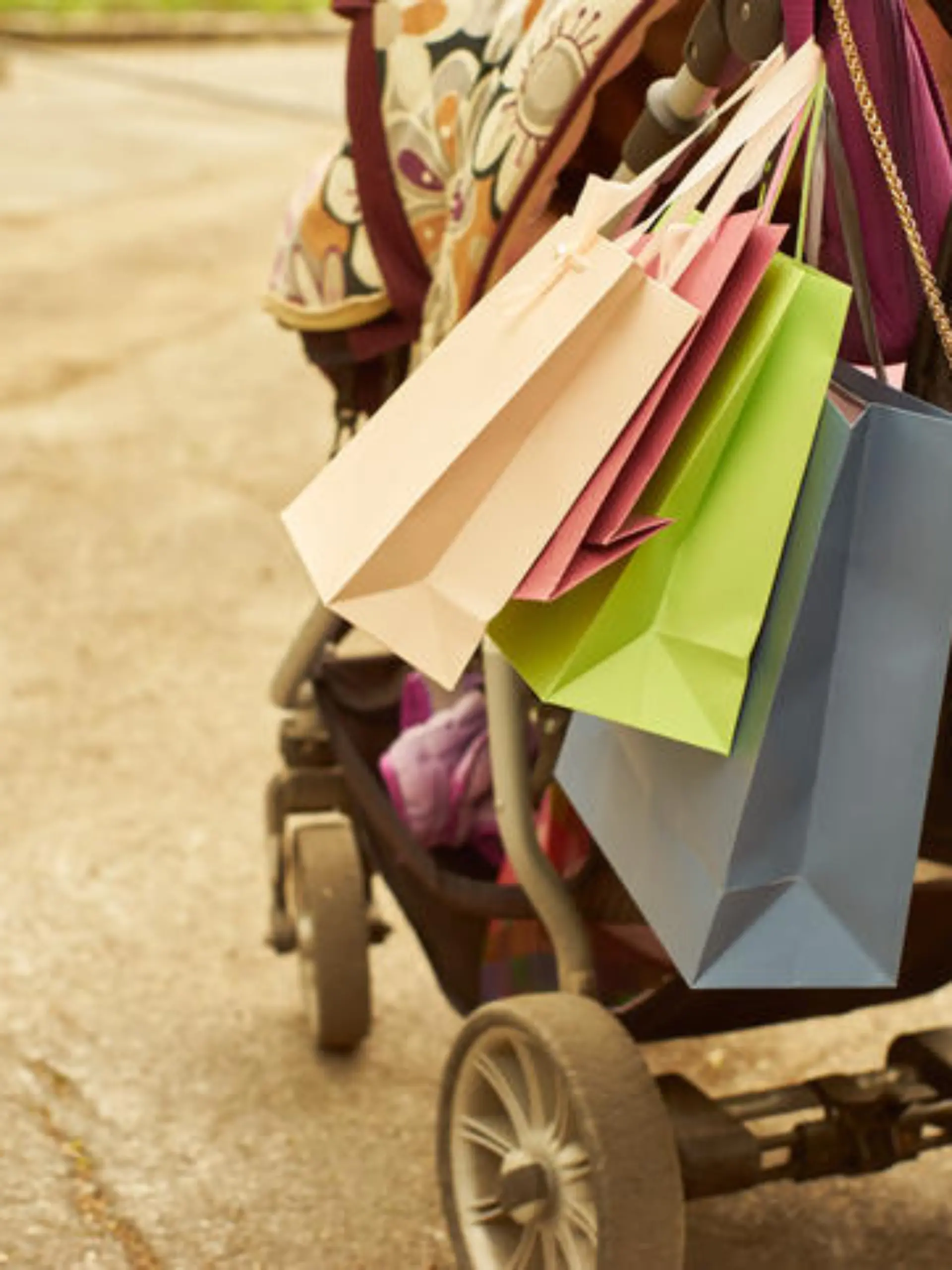 Outdoor crop shot of baby carriage with shopping bags. Copy space.