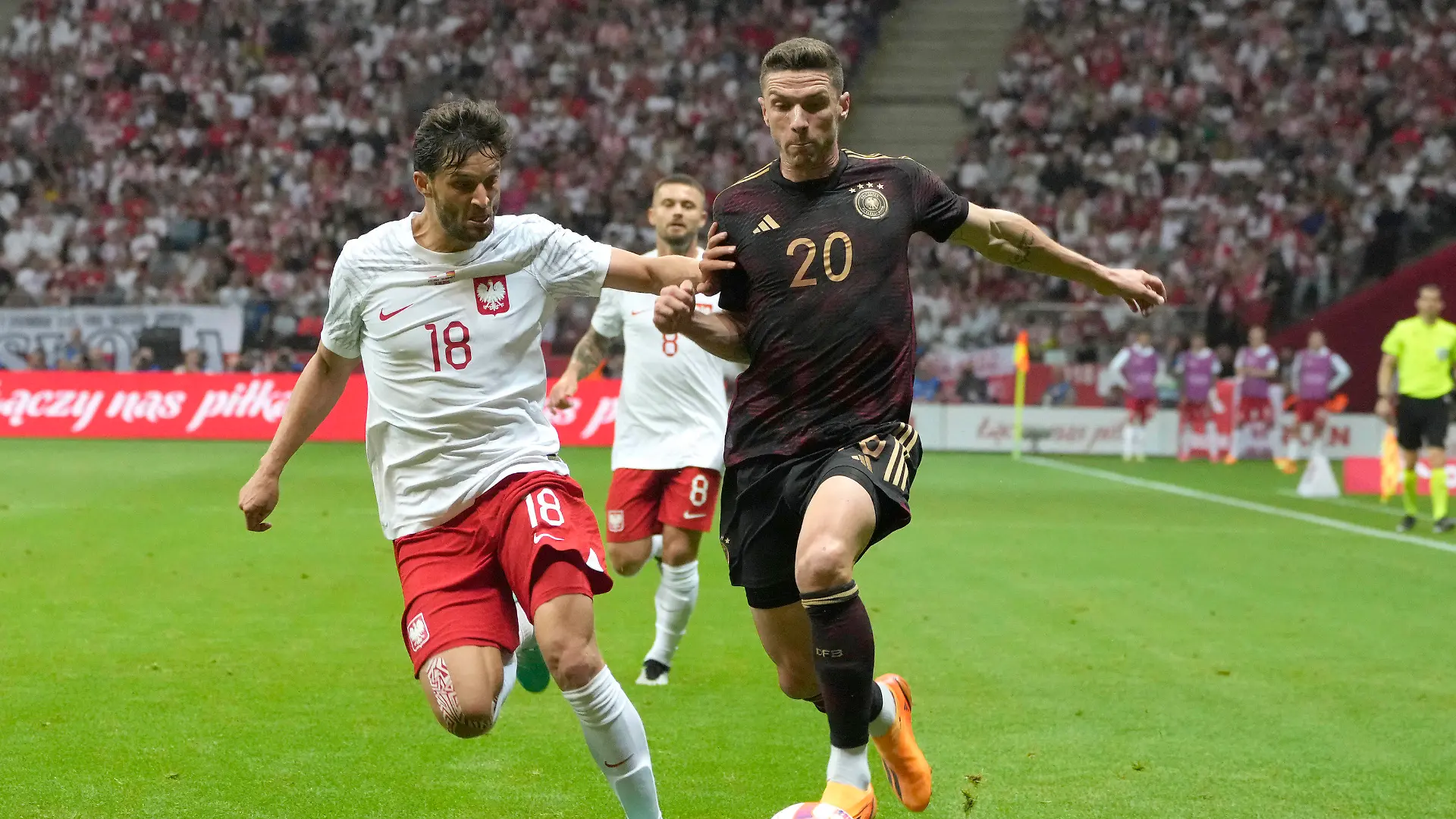 Poland' Bartosz Bereszynski, left, challenges for the ball with Germany's Robin Gosens during the international friendly soccer match between Poland and Germany at the Narodowy stadium in Warsaw, Poland, Friday, June 16, 2023. (AP Photo/Czarek Sokolowski)
