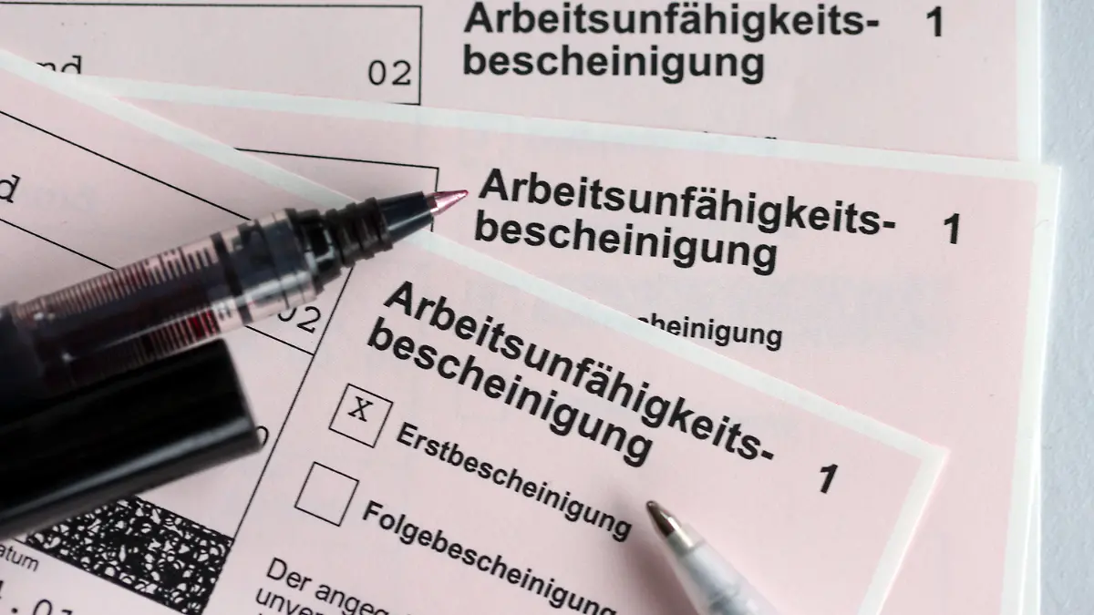 ARCHIV - 14.01.2022, Mecklenburg-Vorpommern, Schwerin: ILLUSTRATION - Stifte liegen auf den Arbeitsunfähigkeitsbescheinigungen für Arbeitnehmer im Falle einer Krankschreibung durch den Arzt. (zu dpa: «Mehr Arbeitsausfall durch Ängste in der Corona-Pandemie ») Foto: Jens Büttner/dpa-Zentralbild/dpa +++ dpa-Bildfunk +++