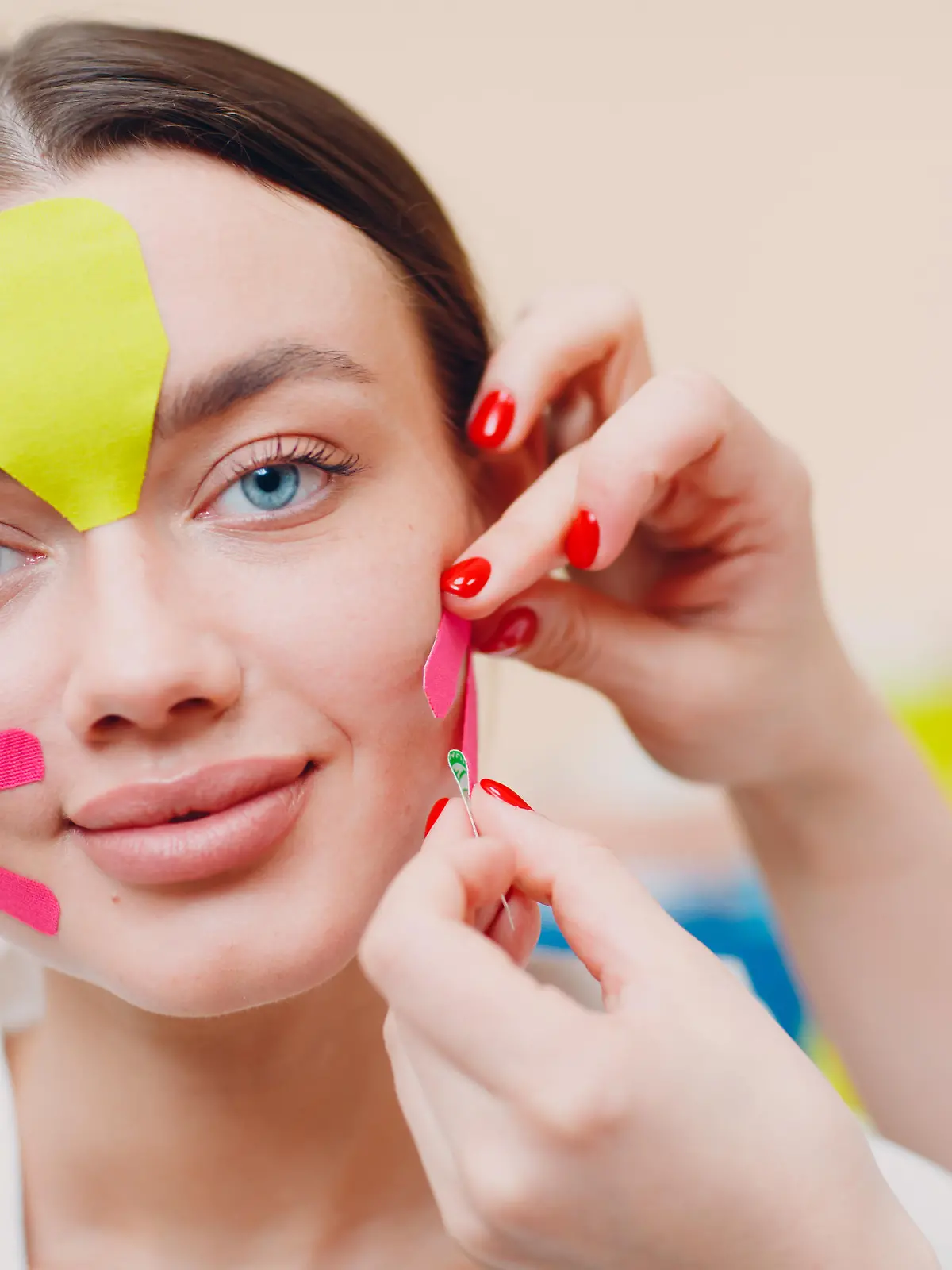 Beautiful woman applying tape lifting treatment procedure on face