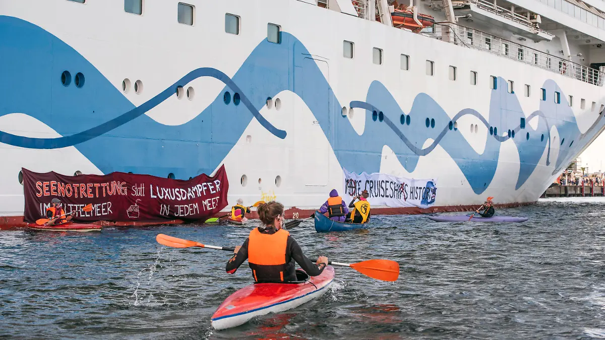 17.06.2023, Mecklenburg-Vorpommern, Rostock-Warnemünde: Klimaaktivisten versuchen auf Kanus und aufblasbaren Booten das Kreuzfahrtschiff «Aida Diva» am Auslaufen zu hindern. Die Aktivisten haben eine Aktion gegen den Kreuzfahrttourismus gestartet. Foto: Frank Hormann/dpa +++ dpa-Bildfunk +++
