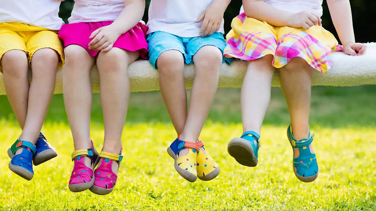 Footwear for children. Group of preschool kids wearing colorful leather shoes. Sandal summer shoe for young child and baby. Preschooler playing outdoor. Child clothing, foot wear and fashion.