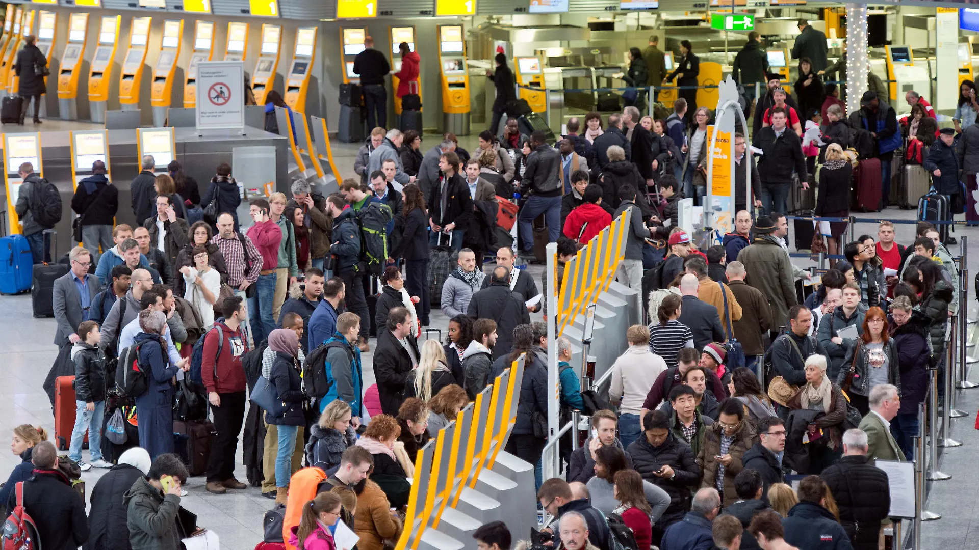 ARCHIV - 01.12.2014, Hessen, Frankfurt/Main: Passagiere warten auf dem Flughafen an Check-In-Schaltern. Nach einer Drohnensichtung ist der Betrieb am Frankfurter Flughafen Donnerstagmorgen wieder aufgenommen worden. Nach rund einer Stunde Sperre könnten die Flieger wieder starten und landen, sagte ein Sprecher des Betreibers Fraport. Foto: Boris Roessler/dpa +++ dpa-Bildfunk +++