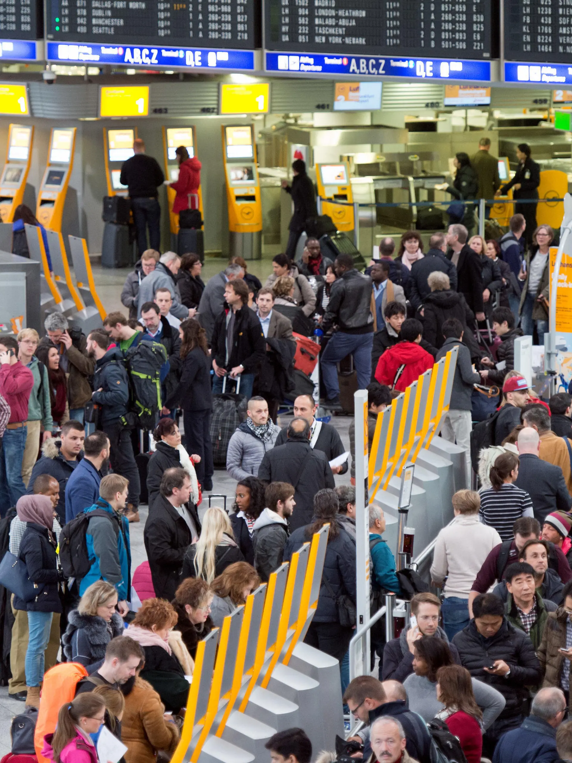 ARCHIV - 01.12.2014, Hessen, Frankfurt/Main: Passagiere warten auf dem Flughafen an Check-In-Schaltern. Nach einer Drohnensichtung ist der Betrieb am Frankfurter Flughafen Donnerstagmorgen wieder aufgenommen worden. Nach rund einer Stunde Sperre könnten die Flieger wieder starten und landen, sagte ein Sprecher des Betreibers Fraport. Foto: Boris Roessler/dpa +++ dpa-Bildfunk +++