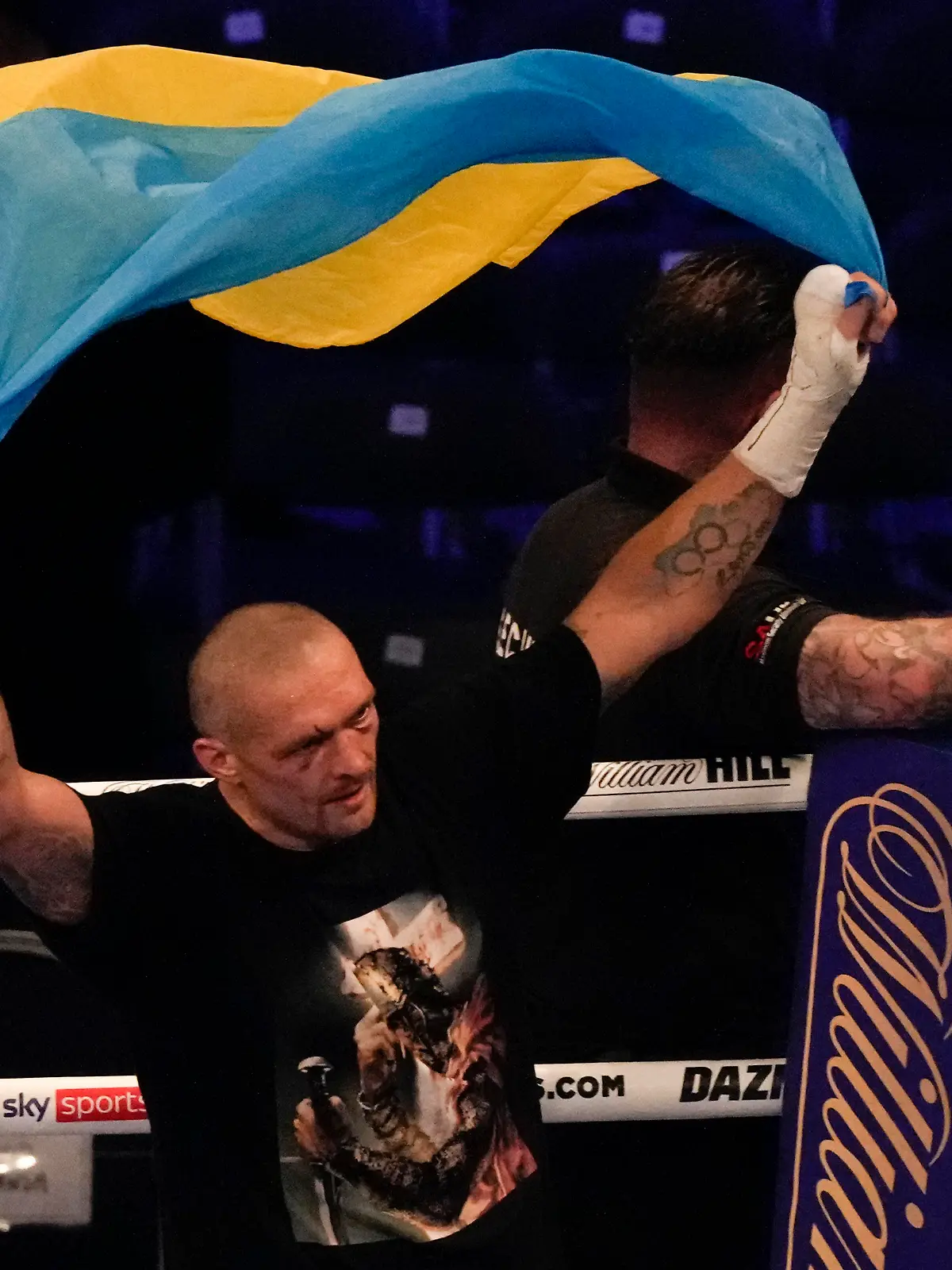 Oleksandr Usyk of Ukraine holds up the Ukrainian flag after his unanimous decision victory over Anthony Joshua of Britain in their WBA (Super), WBO and IBF boxing title bout at the Tottenham Hotspur Stadium in London, Saturday, Sept. 25, 2021. (AP Photo/Frank Augstein)