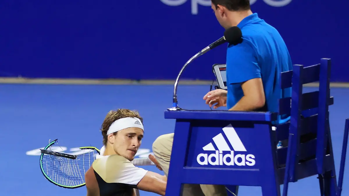 In this photo released by MexTenis, third-ranked Alexander Zverev of Germany smashes his racket on the umpire's chair moments after losing a doubles match of the Mexican Open tennis tournament in Acapulco, Mexico, Tuesday, Feb. 22, 2022. Zverev was thrown out of the Mexican Open after he struck the umpire's chair three times, sat for a moment, then got back up and yelled at umpire Alessandro Germani that he "destroyed the whole (expletive) match" and struck the chair once more with his racket as the umpire climbed down. (Marcos Dominguez/MexTenis via AP)