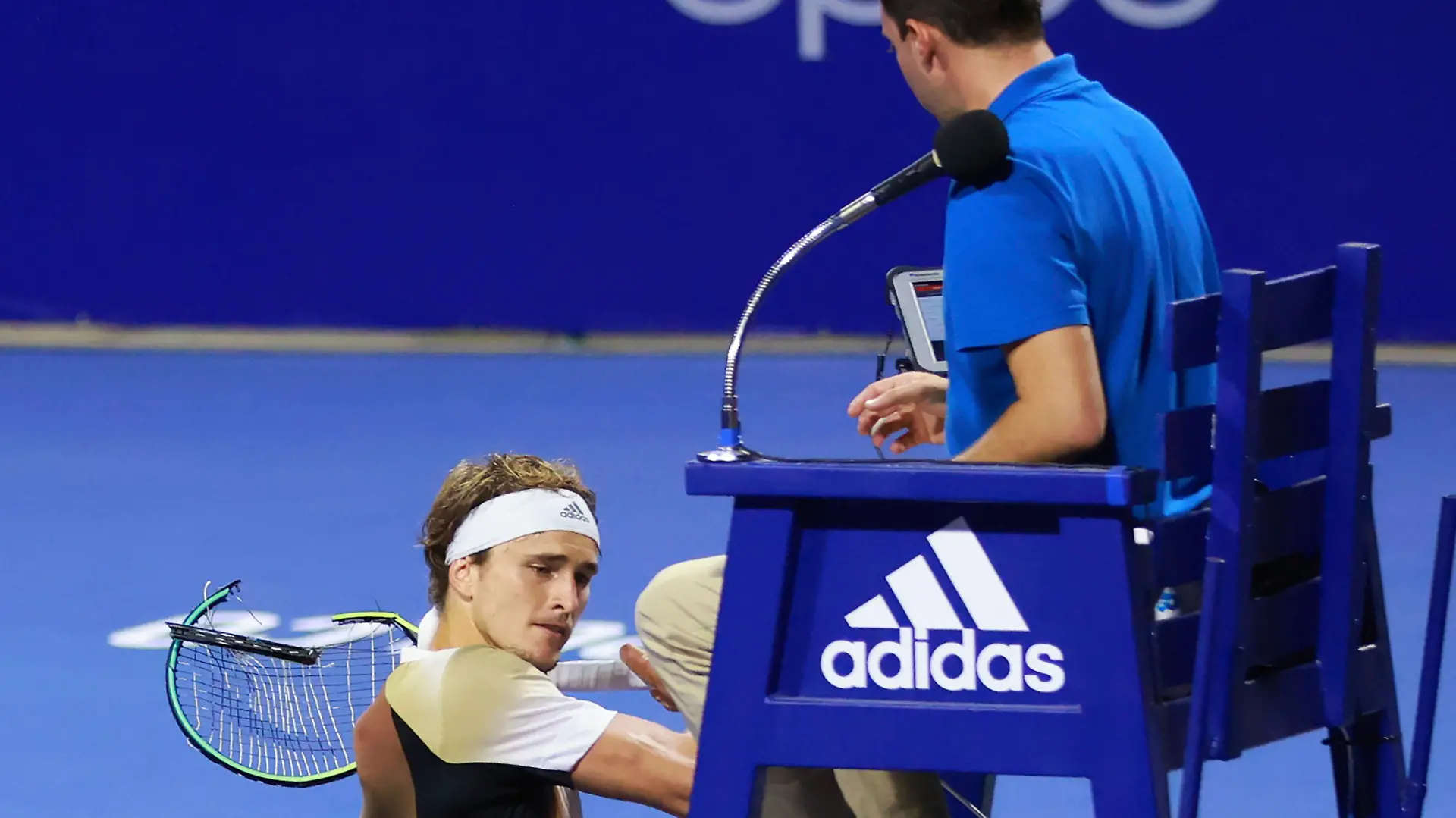 In this photo released by MexTenis, third-ranked Alexander Zverev of Germany smashes his racket on the umpire's chair moments after losing a doubles match of the Mexican Open tennis tournament in Acapulco, Mexico, Tuesday, Feb. 22, 2022. Zverev was thrown out of the Mexican Open after he struck the umpire's chair three times, sat for a moment, then got back up and yelled at umpire Alessandro Germani that he "destroyed the whole (expletive) match" and struck the chair once more with his racket as the umpire climbed down. (Marcos Dominguez/MexTenis via AP)