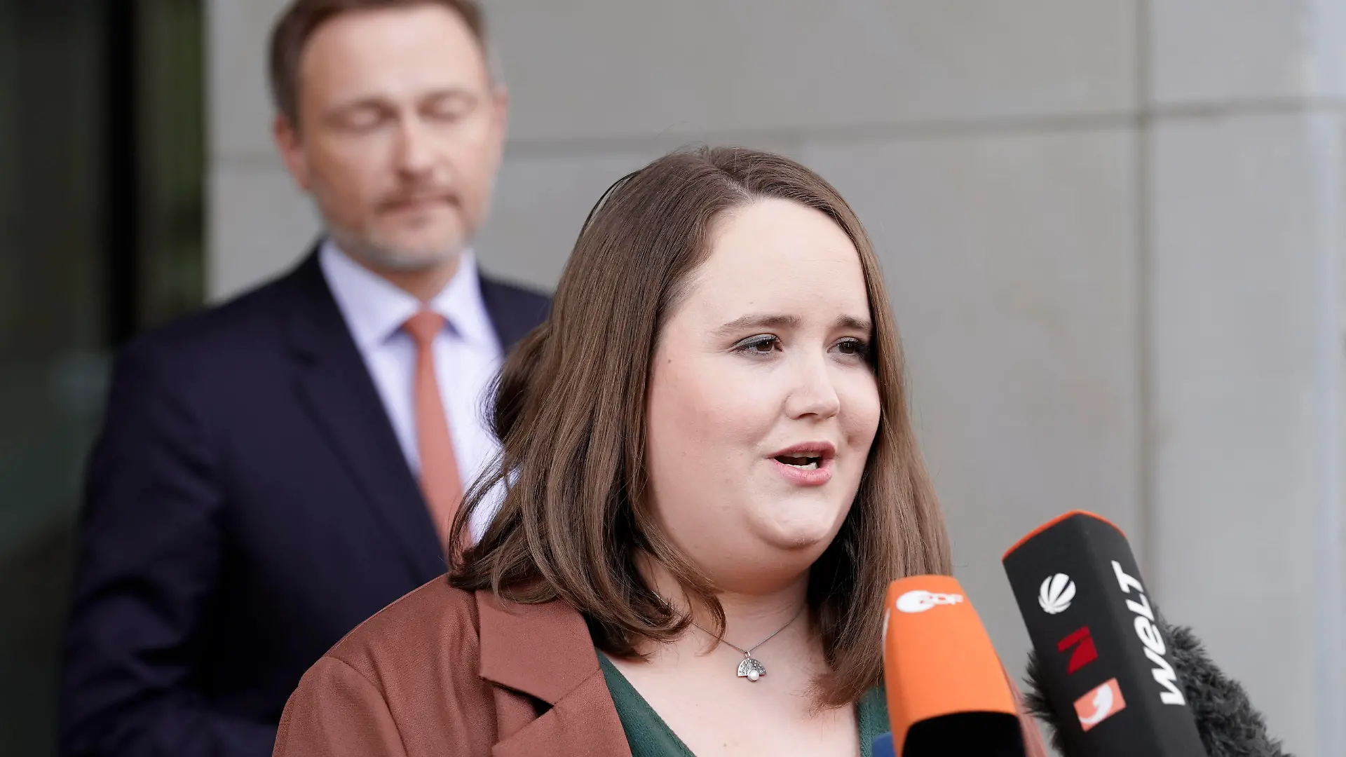 Statement mit den Parteivorsitzenden der drei Ampel-Parteien Aktuell, 24.03.2022, Berlin, Ricarda Lang Buendnis90/ Die Gruenen und Christian Lindner FDP im Hintergrund beim gemeinsamen Statement der Parteivorsitzenden von SPD, Buendnis90/Die Gruenen und FDP zum Entlastungspaket im Nachgang an den Koalitionsausschuss vor dem Bundestagsgebaeude Berlin Berlin Deutschland *** Statement with the party leaders of the three traffic light parties Current, 24 03 2022, Berlin, Ricarda Lang Buendnis90 The Greens and Christian Lindner FDP in the background at the joint statement of the party leaders of SPD, Buendnis90 The Greens and FDP on the relief package in the aftermath of the coalition committee in front of the Bundestag building Berlin Berl