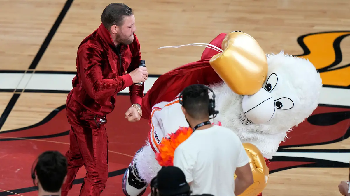 ARCHIV - 10.06.2023, USA, Miami: Basketball: NBA, Denver Nuggets - Miami Heat; Play-off-Runde, NBA-Finale, Finale, 4. Spieltag: Der ehemalige UFC-Champion Conor McGregor schlägt das Maskottchen der Miami Heat während einer Spielpause nieder. Der Mann, der Burnies Kostüm trägt, musste ärztlich behandelt werden. (zu dpa: «Vorwürfe von sexuellem Missbrauch nach NBA-Spiel gegen McGregor») Foto: Lynne Sladky/AP/dpa +++ dpa-Bildfunk +++