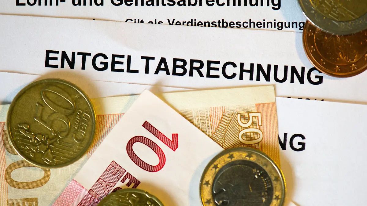 ARCHIV - ILLUSTRATION - Auf Lohn- und Gehaltsabrechnungen (Entgeltabrechnungen) liegen Euromünzen und Eurogeldscheine, aufgenommen am 31.01.2013 in Dresden (Sachsen). Foto: Arno Burgi/dpa (zu dpa " Statistisches Bundesamt zur Vierteljährlichen Verdiensterhebung (Entwicklung der Nominal- und Reallöhne), vorläufige Ergebnisse Jahr 2015" vom 04.02.2016) +++(c) dpa - Bildfunk+++