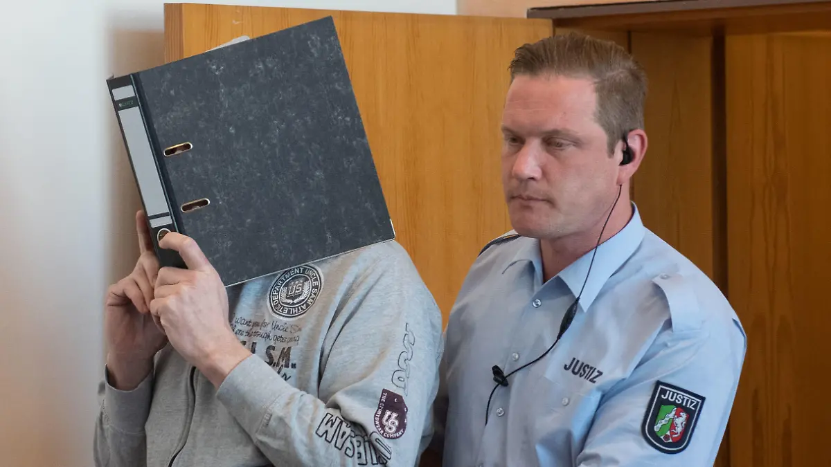 27.06.2019, Nordrhein-Westfalen, Detmold: Der Angeklagte Andreas V. wird von einem Justizmitarbeiter in den Saal des Landgerichtes geführt. Links sein Anwalt Johannes Salmen. Über viele Jahre hinweg sollen Kinder auf einem Campingplatz im nordrhein-westfälischen Lügde hundertfach schwer sexuell missbraucht worden sein. Drei Männer sind angeklagt. Ein 56-Jähriger aus Lügde und ein 34-Jähriger aus Steinheim sollen den Missbrauch begangen und teilweise gefilmt haben. Ein 49-Jähriger aus dem niedersächsischen Stade soll an Webcam-Übertragungen teilgenommen haben. Foto: Bernd Thissen/dpa-POOL/dpa +++ dpa-Bildfunk +++