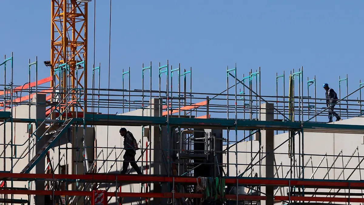 22.03.2022, Bayern, Landsberg am Lech: Handwerker arbeiten am Neubau eines Mehrfamilienhauses an einem Baugerüst. Das ifo-Institut veröffentlicht am Mittwoch seine neue Konjunkturprognose. (zu dpa «Ifo-Institut veröffentlicht neue Konjunkturprognose») Foto: Karl-Josef Hildenbrand/dpa +++ dpa-Bildfunk +++