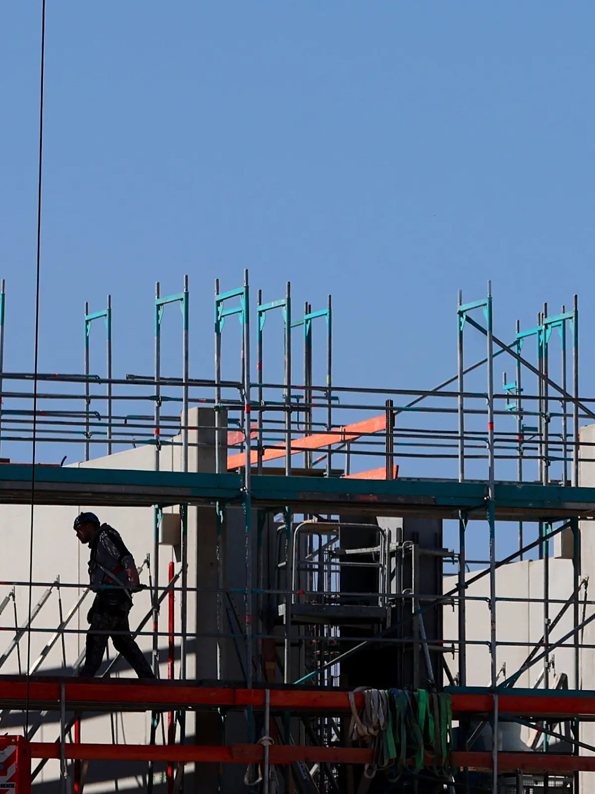 22.03.2022, Bayern, Landsberg am Lech: Handwerker arbeiten am Neubau eines Mehrfamilienhauses an einem Baugerüst. Das ifo-Institut veröffentlicht am Mittwoch seine neue Konjunkturprognose. (zu dpa «Ifo-Institut veröffentlicht neue Konjunkturprognose») Foto: Karl-Josef Hildenbrand/dpa +++ dpa-Bildfunk +++