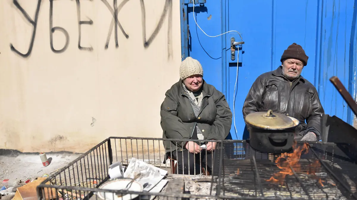 Ukraine-Konflikt, Eindrücke aus der Region Mariupol MARIUPOL, UKRAINE - MARCH 22, 2022: Citizens cook over an open fire on Shevchenko Boulevard. On March 22, Deputy Information Minister Bezsonov stated the Donetsk Peoples Republic had managed to liberate at least half the city. According to Col Gen Mizintsev, Chief of the Russian National Defence Management Centre, more than 68,000 civilians have evacuated from Mariupol caught in the middle of a humanitarian disaster. Nikolai Trishin/TASS PUBLICATIONxINxGERxAUTxONLY TS128E7B