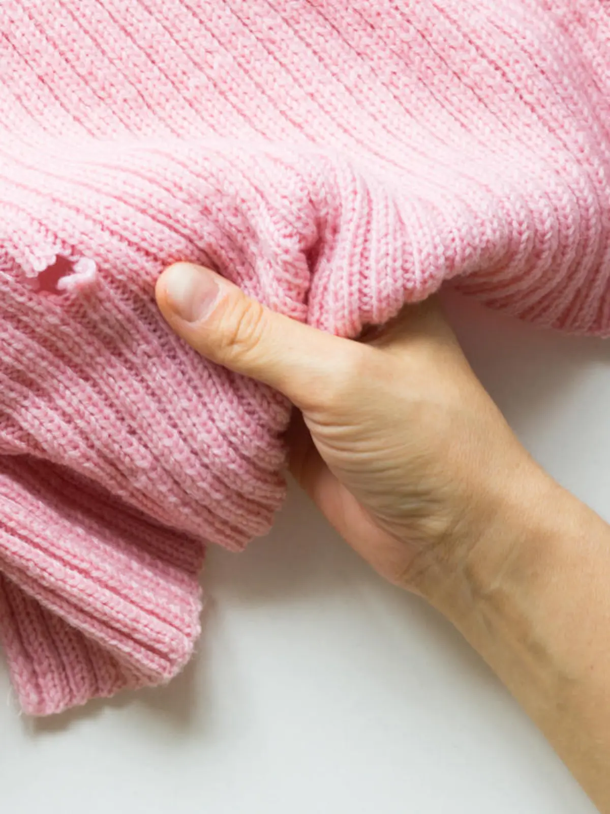 Woman hands holding the knitted thing with hole made by mole