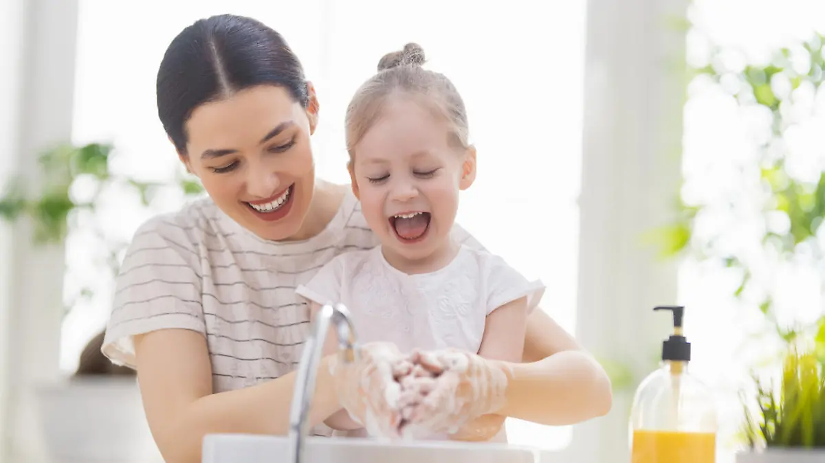 A cute little girl and her mother are washing their hands. Protection against infections and viruses.