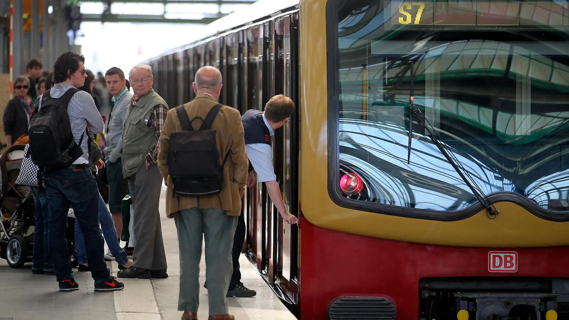 Fahrgäste stehen am Montag (23.05.2011) auf dem Ostbahnhof in Berlin neben einem S-Bahn-Zug und beobachten den Zugführer, der den Zug abschließt. Ein Kabelbrand hatte in den frühen Morgenstunden zu erheblichen Zugausfällen im Ostteil der Stadt gesorgt und zu massiven Verkehrsproblemen im Berufsverkehr geführt. Foto: Wolfgang Kumm dpa  +++(c) dpa - Bildfunk+++