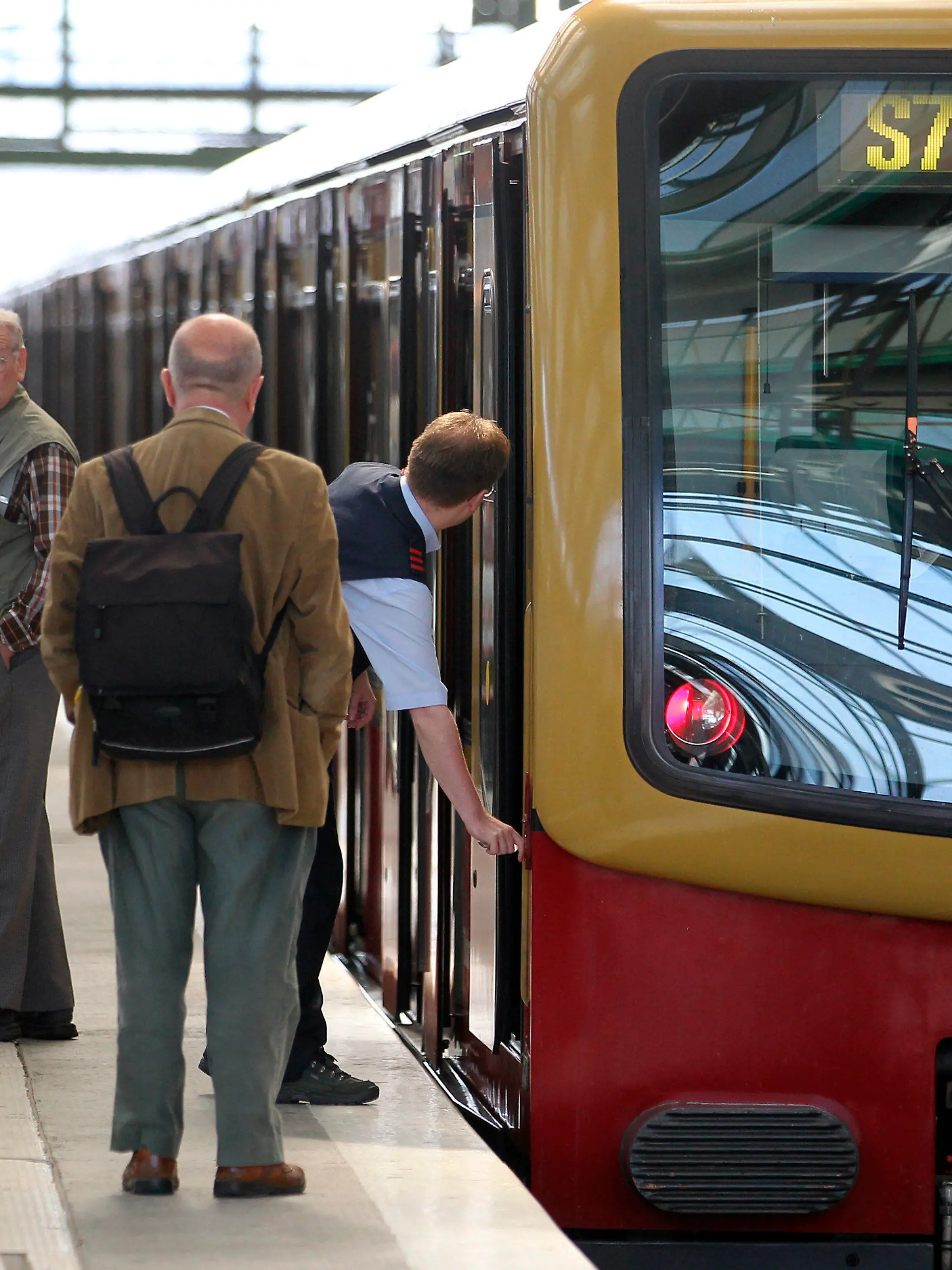 Fahrgäste stehen am Montag (23.05.2011) auf dem Ostbahnhof in Berlin neben einem S-Bahn-Zug und beobachten den Zugführer, der den Zug abschließt. Ein Kabelbrand hatte in den frühen Morgenstunden zu erheblichen Zugausfällen im Ostteil der Stadt gesorgt und zu massiven Verkehrsproblemen im Berufsverkehr geführt. Foto: Wolfgang Kumm dpa  +++(c) dpa - Bildfunk+++