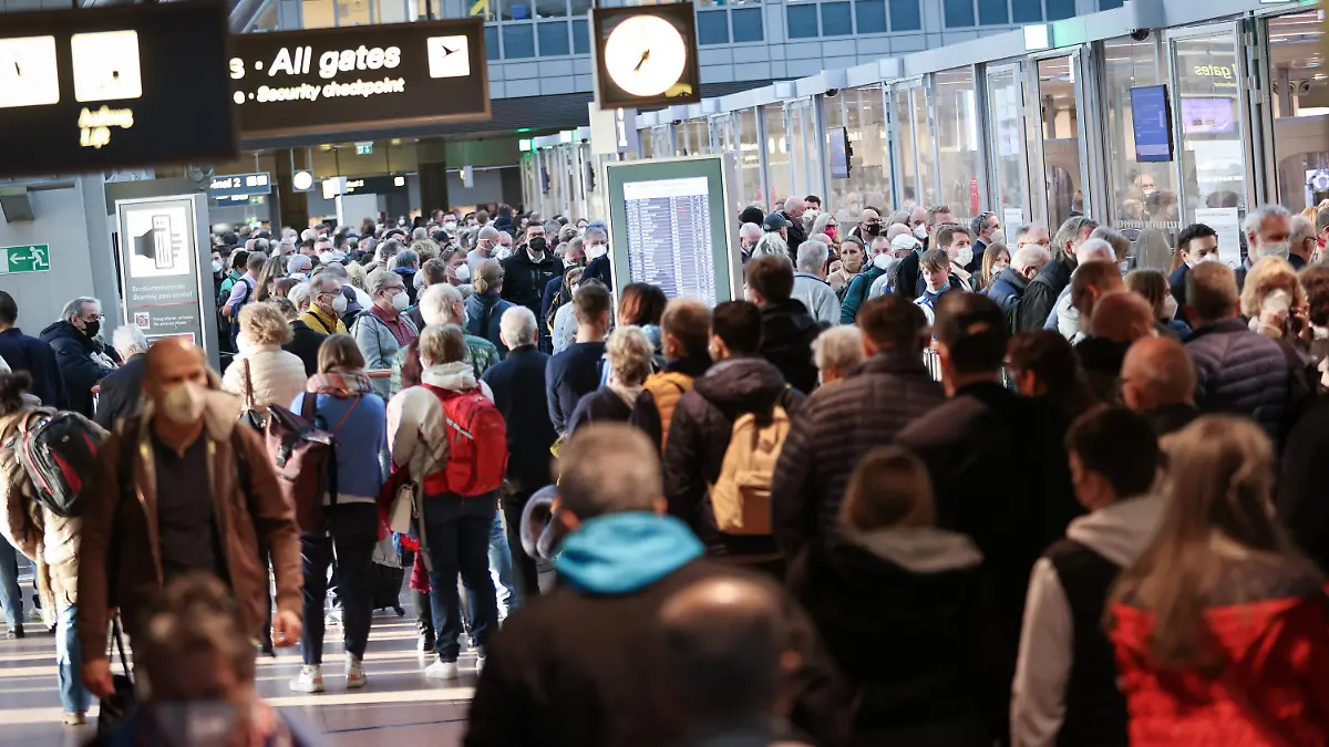 16.03.2022, Hamburg: Reisende stehen in einer langen Schlange vor der Sicherheitskontrolle im Flughafen Hamburg. Nach den Warnstreiks der Gewerkschaft Verdi von Sicherheitskräften in der Fluggastkontrolle kam es am Morgen zu langen Wartezeiten am Hamburger Flughafen. Foto: Christian Charisius/dpa +++ dpa-Bildfunk +++
