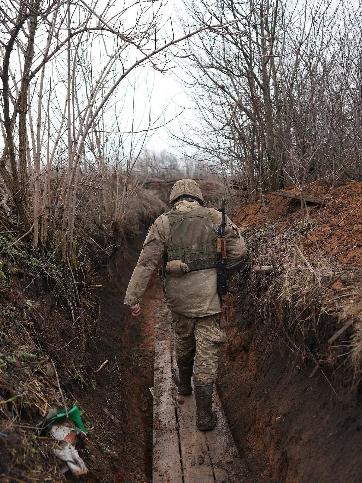23.02.2022, Ukraine, Svitlodarsk: Ein ukrainischer Soldat geht durch einen Graben an der Trennlinie zwischen dem von der Ukraine und dem von pro-russischen Separatisten gehaltenen Gebiet in der Nähe von Svitlodarsk in der Ostukraine. Die Ukraine rüstet sich für einen Krieg mit Russland. Präsident Selenskyj kündigte eine Teilmobilmachung von Reservisten an. Foto: Evgeniy Maloletka/AP/dpa +++ dpa-Bildfunk +++
