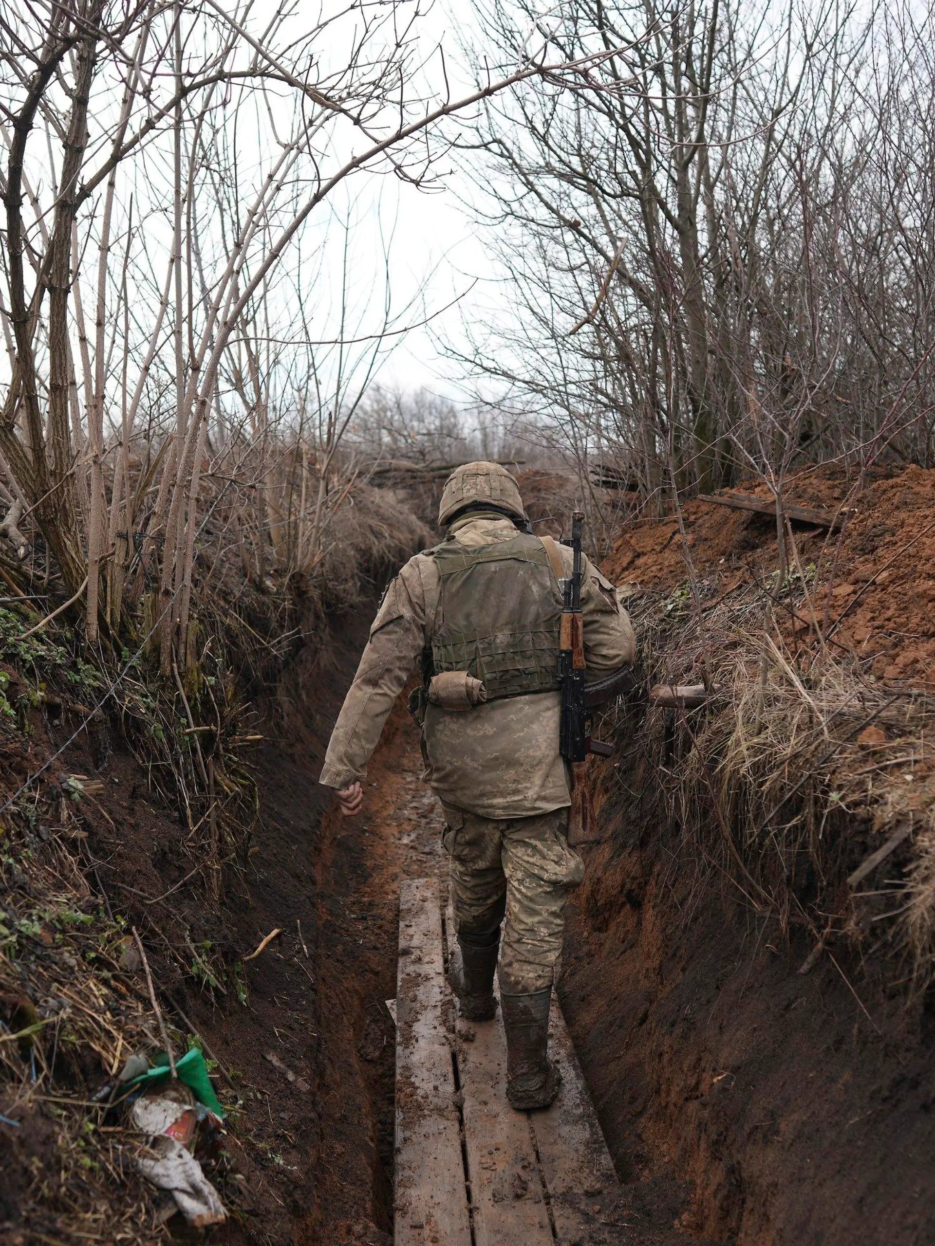 23.02.2022, Ukraine, Svitlodarsk: Ein ukrainischer Soldat geht durch einen Graben an der Trennlinie zwischen dem von der Ukraine und dem von pro-russischen Separatisten gehaltenen Gebiet in der Nähe von Svitlodarsk in der Ostukraine. Die Ukraine rüstet sich für einen Krieg mit Russland. Präsident Selenskyj kündigte eine Teilmobilmachung von Reservisten an. Foto: Evgeniy Maloletka/AP/dpa +++ dpa-Bildfunk +++