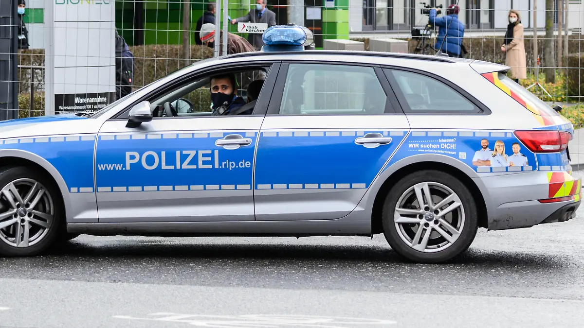 Ein Polizeifahrzeug patrouilliert auf der Straße vor dem Mainzer Unternehmenssitz Biontech während eines Pressetermins mit dem Vorstandsvorsitzenden Sahin. Die Firma Biontech ist ein Biotechnologieunternehmen, das unter anderem an Impfstoffen gegen das Coronavirus forscht. Die EU-Kommission hat kürzlich dem Corona-Impfstoff des Unternehmens Biontech und seines US-Partners Pfizer die bedingte Marktzulassung erteilt.
