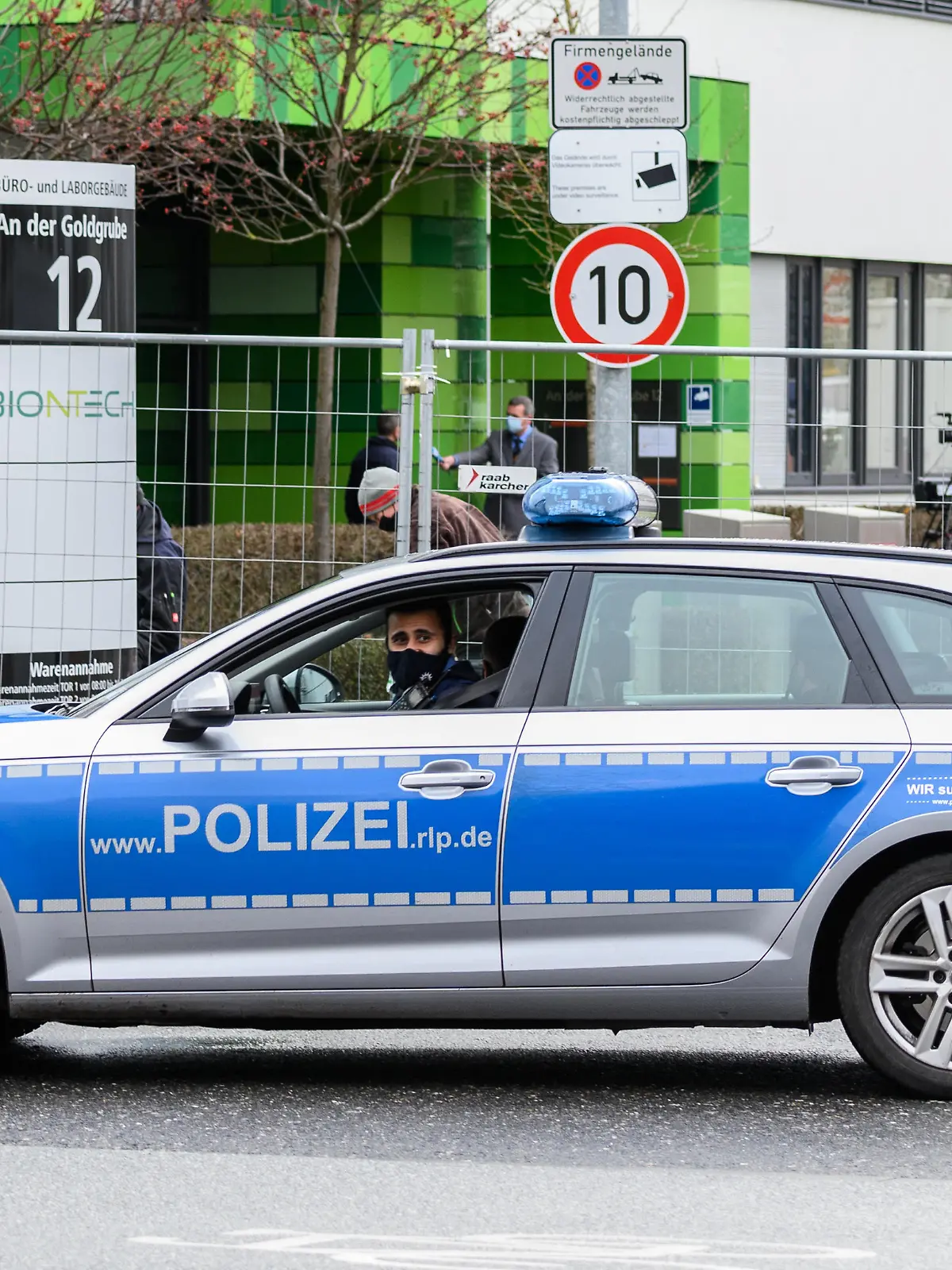 Ein Polizeifahrzeug patrouilliert auf der Straße vor dem Mainzer Unternehmenssitz Biontech während eines Pressetermins mit dem Vorstandsvorsitzenden Sahin. Die Firma Biontech ist ein Biotechnologieunternehmen, das unter anderem an Impfstoffen gegen das Coronavirus forscht. Die EU-Kommission hat kürzlich dem Corona-Impfstoff des Unternehmens Biontech und seines US-Partners Pfizer die bedingte Marktzulassung erteilt.