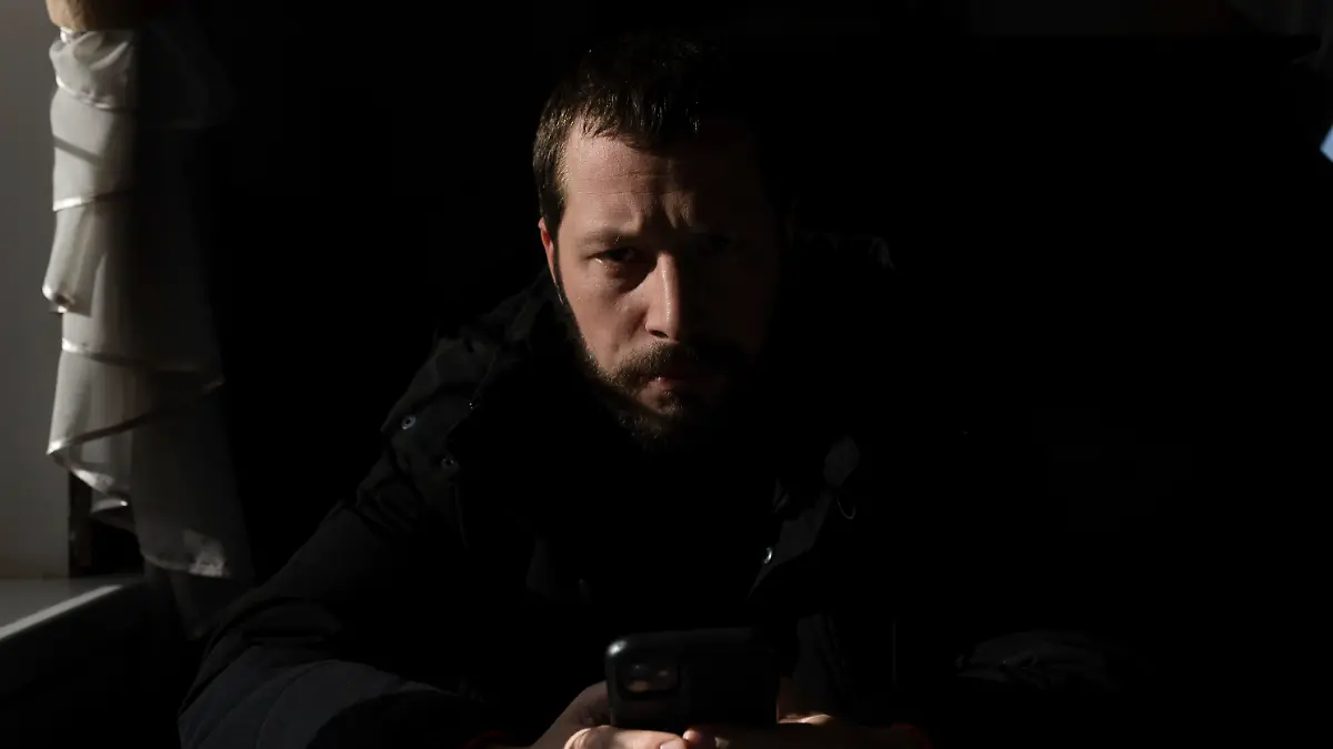 Associated Press videographer Mstyslav Chernov reads news on his phone three days before the start of Russian invasion in Volnovakha, Ukraine, Monday, Feb. 21, 2022. On the evening of Feb. 23, Chernov headed to Mariupol with colleague Evgeniy Maloletka. (AP Photo/Evgeniy Maloletka)