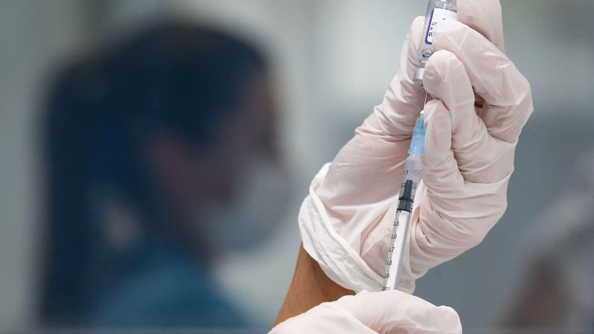 ARCHIV - 25.11.2021, Baden-Württemberg, Gerlingen: Eine Frau zieht eine Dosis des Impfstoffes von Biontech/Pfizer für eine Corona-Impfung auf. Wer als Beschäftigter im Gesundheitswesen am Dienstag (15.03.2022) keine Impfung nachweisen kann, muss künftig unter Umständen mit arbeitsrechtlichen Konsequenzen rechnen. (zu dpa/lsw «Impfpflicht im Gesundheitswesen läuft an»). Foto: Marijan Murat/dpa +++ dpa-Bildfunk +++