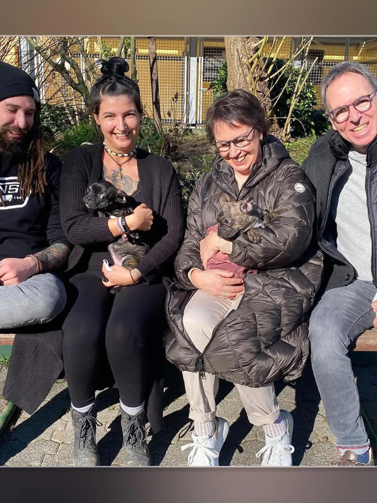 Französische Bulldoggen-Welpen im Arm ihrer neuen Besitzer.