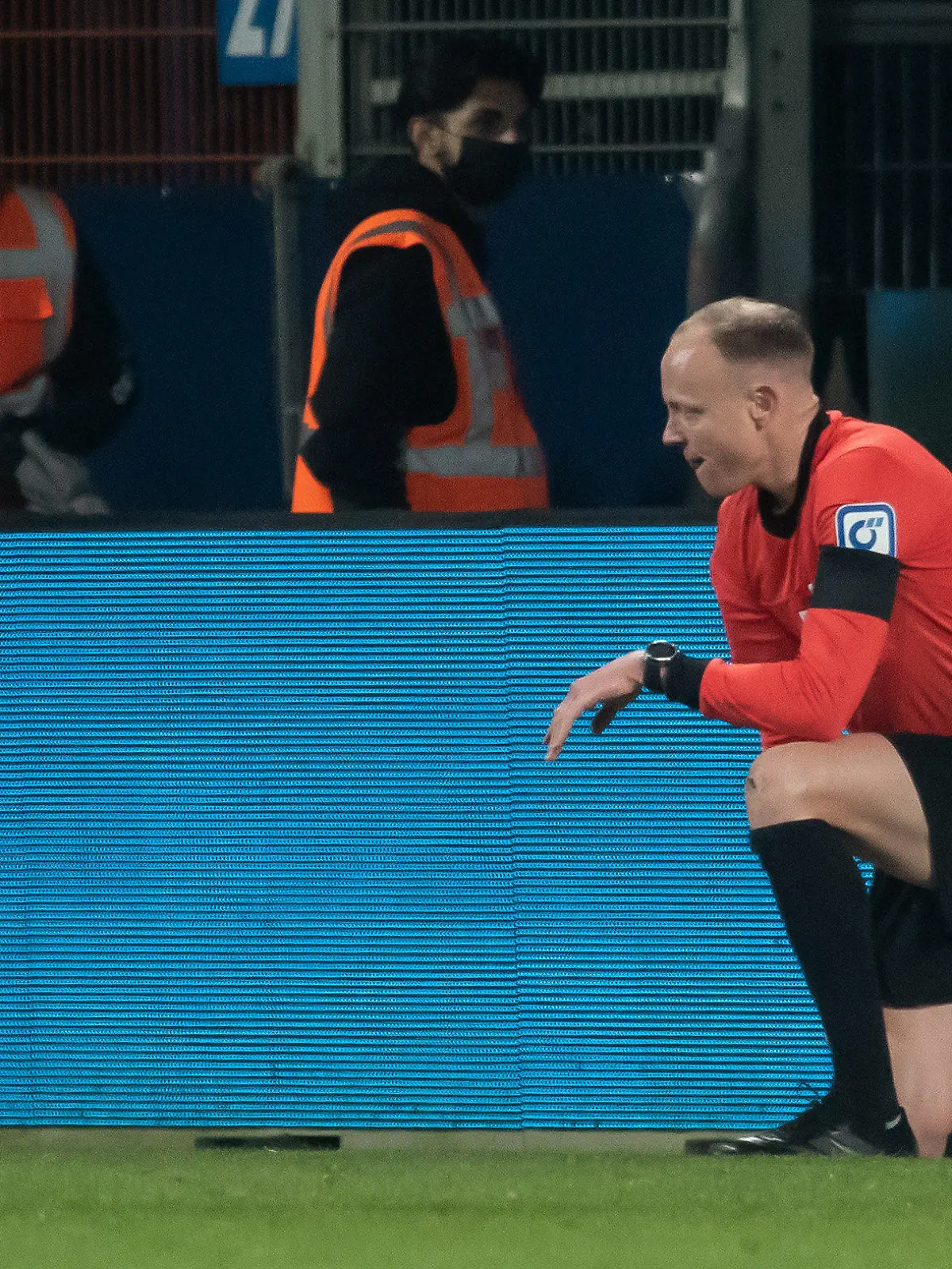 18.03.2022, Nordrhein-Westfalen, Bochum: Fußball: Bundesliga, VfL Bochum - Bor. Mönchengladbach, 27. Spieltag, Vonovia Ruhrstadion. Schiedsrichterassistent Christian Gittelmann hat seine Fahne verloren und kniet auf dem Rasen, nachdem er einen Becher an den Kopf bekommen hatte. Der Linienrichter wurde nach dem anschließenden Spielabbruch ins Krankenhaus gebracht. Foto: Bernd Thissen/dpa +++ dpa-Bildfunk +++