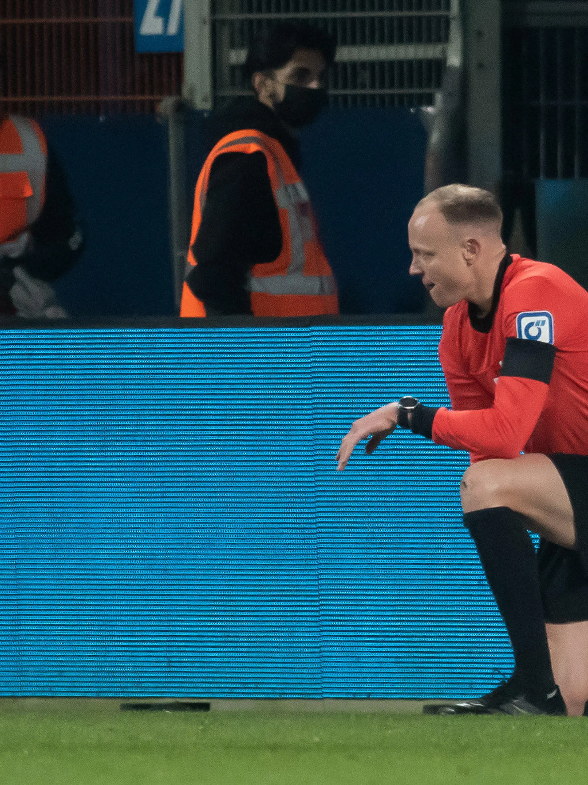 18.03.2022, Nordrhein-Westfalen, Bochum: Fußball: Bundesliga, VfL Bochum - Bor. Mönchengladbach, 27. Spieltag, Vonovia Ruhrstadion. Schiedsrichterassistent Christian Gittelmann hat seine Fahne verloren und kniet auf dem Rasen, nachdem er einen Becher an den Kopf bekommen hatte. Der Linienrichter wurde nach dem anschließenden Spielabbruch ins Krankenhaus gebracht. Foto: Bernd Thissen/dpa +++ dpa-Bildfunk +++