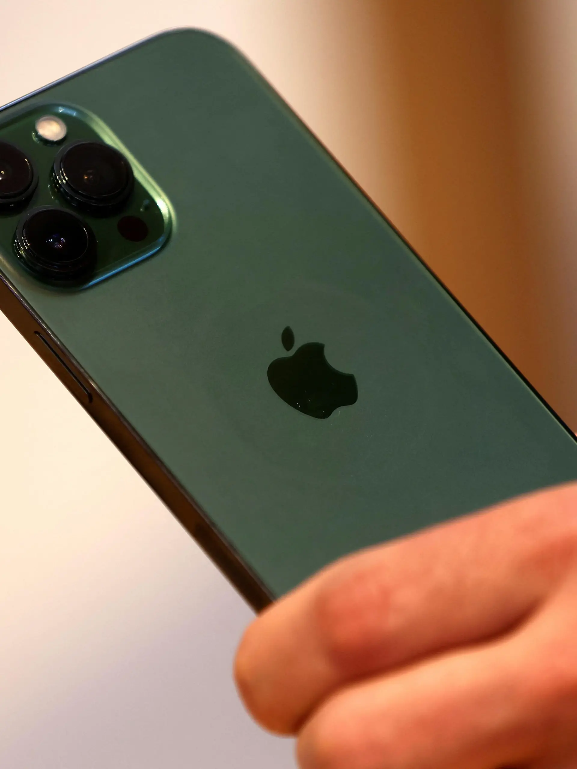 A customers holds the new green colour Apple iPhone 13 pro shortly after it went on sale inside the Apple Store on 5th Avenue in Manhattan in New York City, New York, U.S., March 18, 2022. REUTERS/Mike Segar