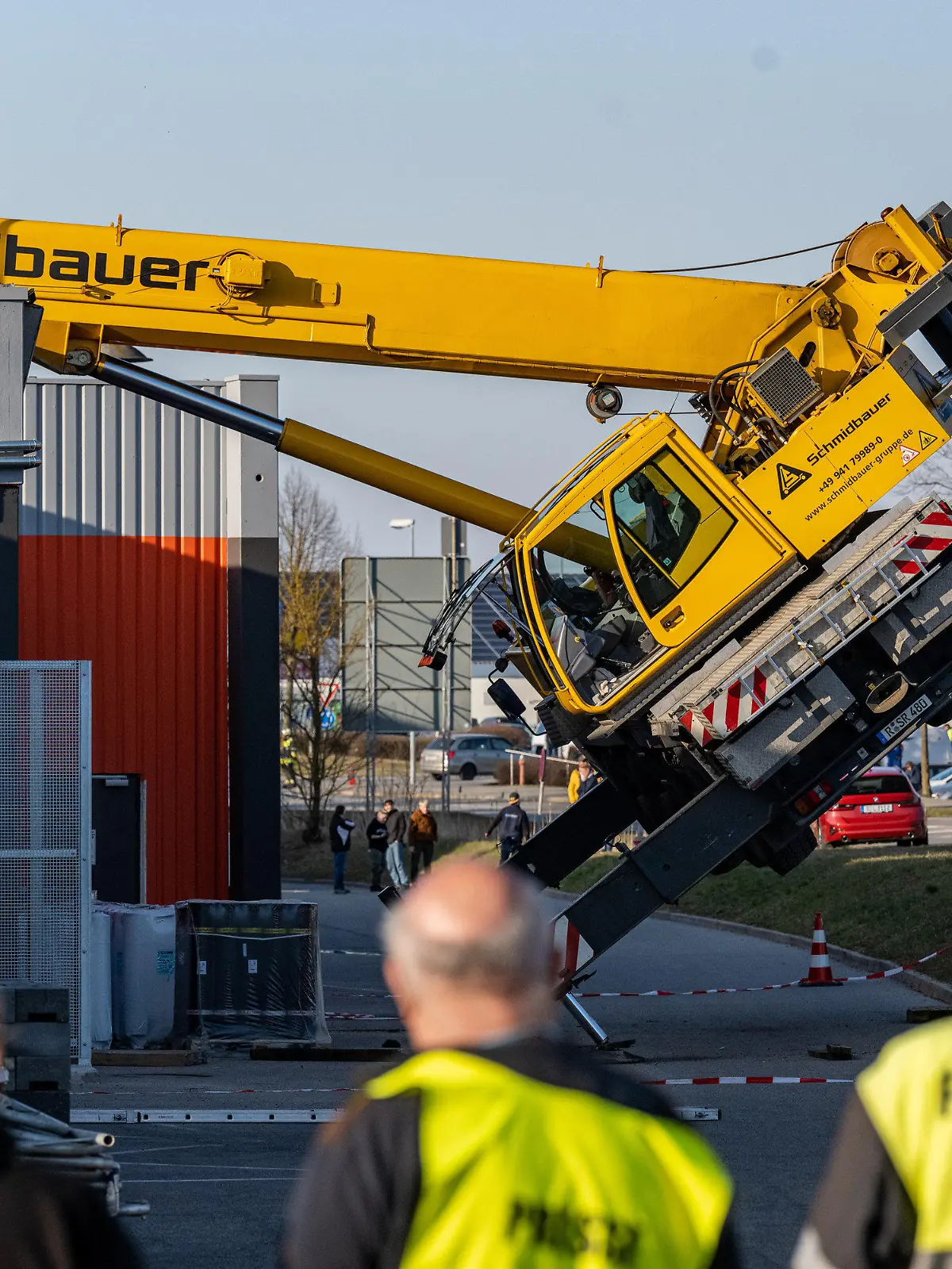 21.03.2022, Bayern, Pentling: Ein Autokran ist mit seinem Ausleger auf das Dach eines Supermarktes gestürzt. Verletzt wurde bei dem Unfall nach ersten Erkenntnissen der Polizei niemand. Das Gebäude sei evakuiert worden. Foto: Armin Weigel/dpa +++ dpa-Bildfunk +++