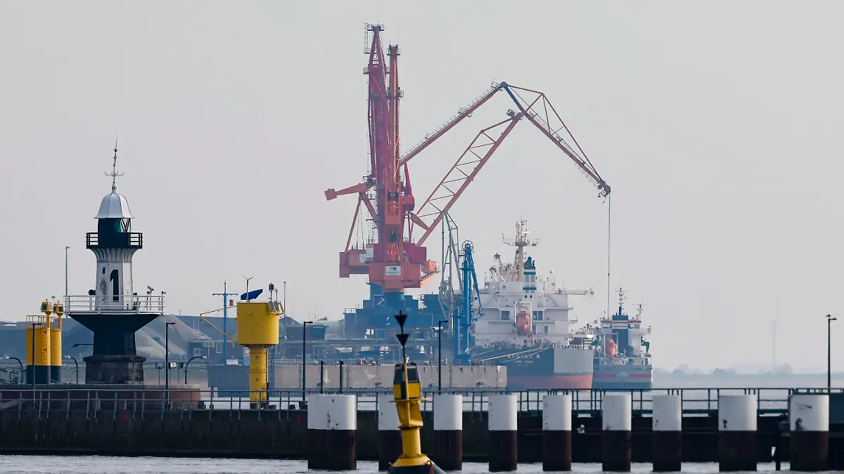 01.03.2022, Schleswig-Holstein, Brunsbüttel: Schiffe werden be- und entladen am Hafen von Brunsbüttel. Die unmittelbare Nachbarschaft ist als Standort für ein neues LNG-Terminal (Windräder stehen vor einem Kohlelager am Elbdeich am Hafen von Brunsbüttel. Das Gebiet ist als Standort für ein neues LNG-Terminal (Liquefied Natural Gas) im Gespräch. Foto: Frank Molter/dpa +++ dpa-Bildfunk +++
