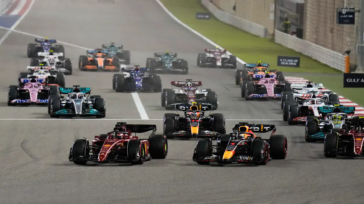 20.03.2022, Bahrain, Sakhir: Motorsport: Formel-1-Weltmeisterschaft, Grand Prix von Bahrain, Rennen. Der monegassische Fahrer Charles Leclerc (vorne links) vom Team Ferrari führt das Fahrerfeld nach dem Start an. Foto: Hassan Ammar/AP/dpa +++ dpa-Bildfunk +++