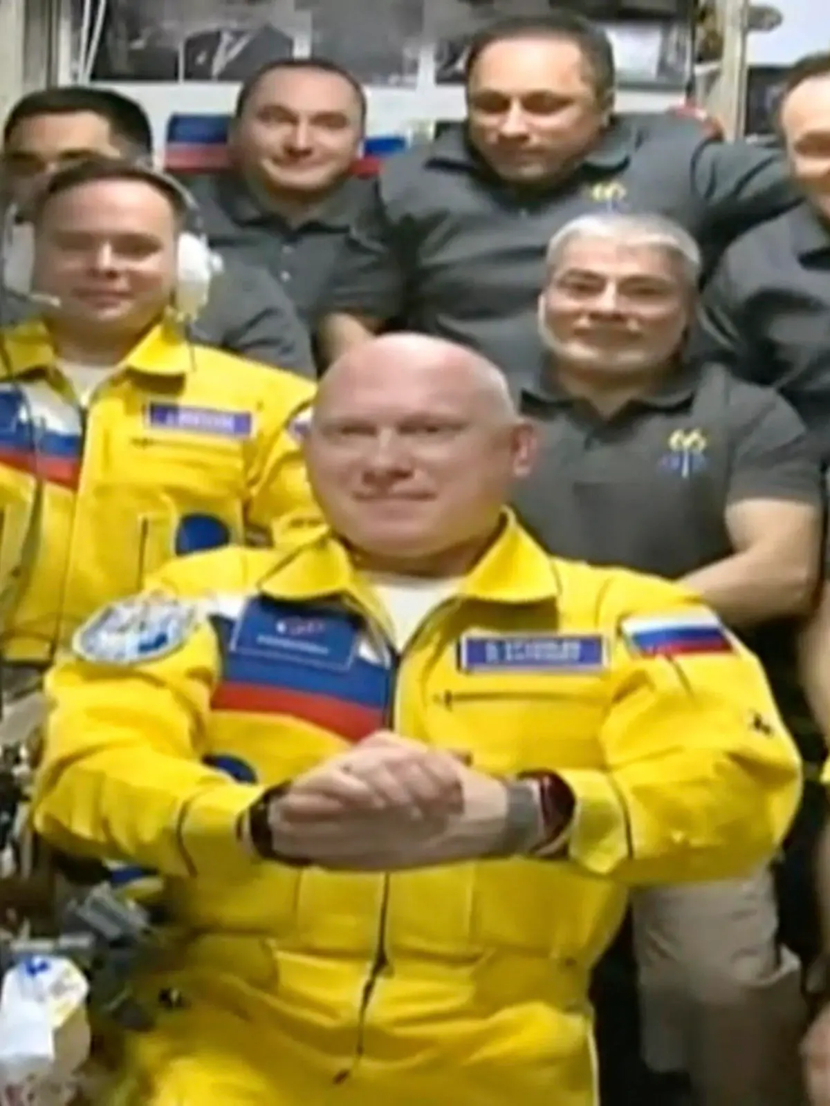 In this frame grab from video provided by Roscosmos, Russian cosmonauts Sergey Korsakov, Oleg Artemyev and Denis Matveyev are seen during a welcome ceremony after arriving at the International Space Station, Friday, March 18, 2022, the first new faces in space since the start of Russia’s war in Ukraine. The crew emerged from the Soyuz capsule wearing yellow flight suits with blue stripes, the colors of the Ukrainian flag. (Roscosmos via AP)
