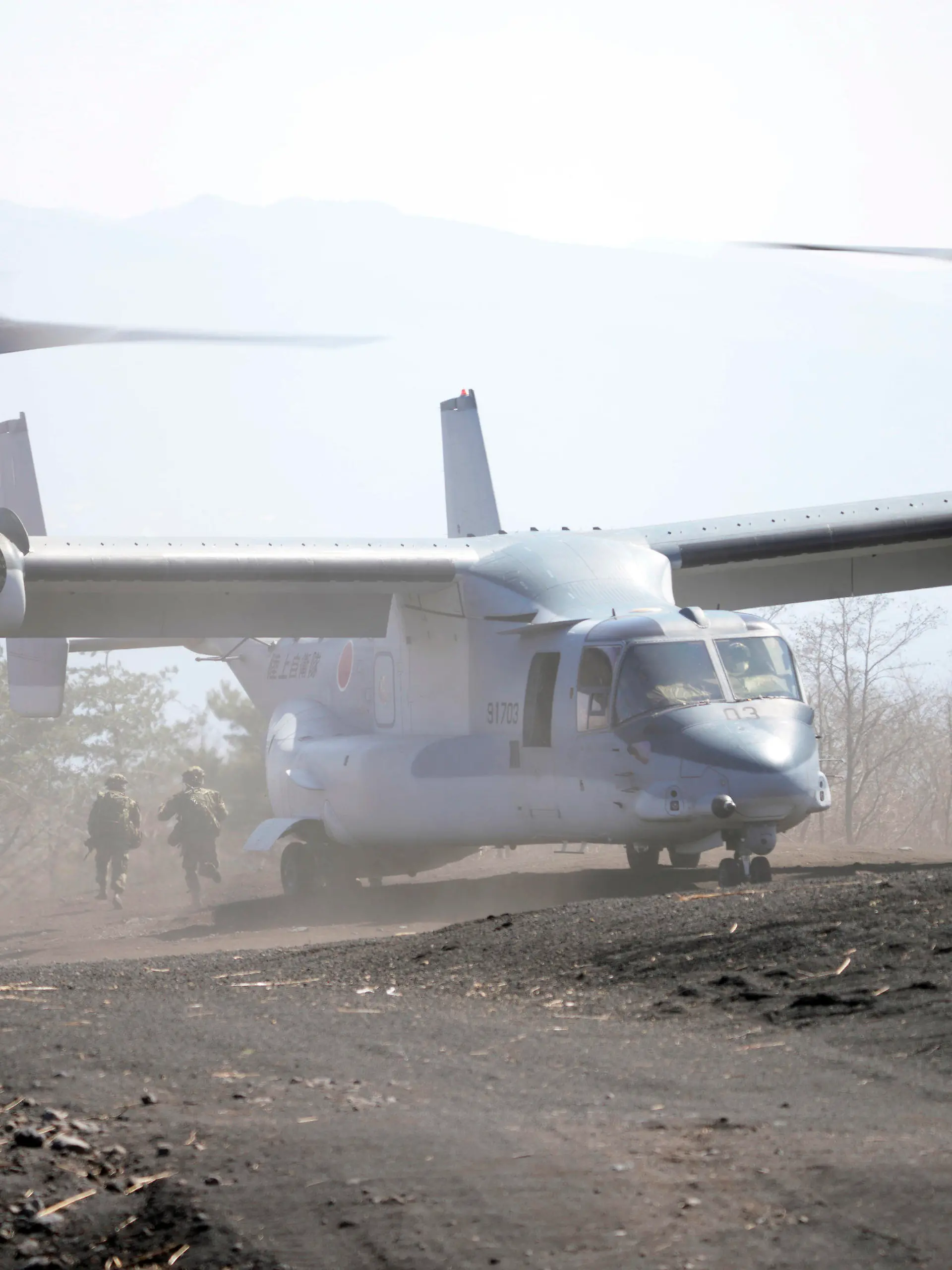 Members of the Japan Ground Self-Defense Force (JGSDF) rush out from a V-22 osprey as they take part in a joint military helicopter borne operation drill between Japan Ground Self-Defense Force (JGSDF) and U.S. Marines at the Higashi Fuji range in Gotemba, southwest of Tokyo, Tuesday, March 15, 2022. (AP Photo/Eugene Hoshiko)