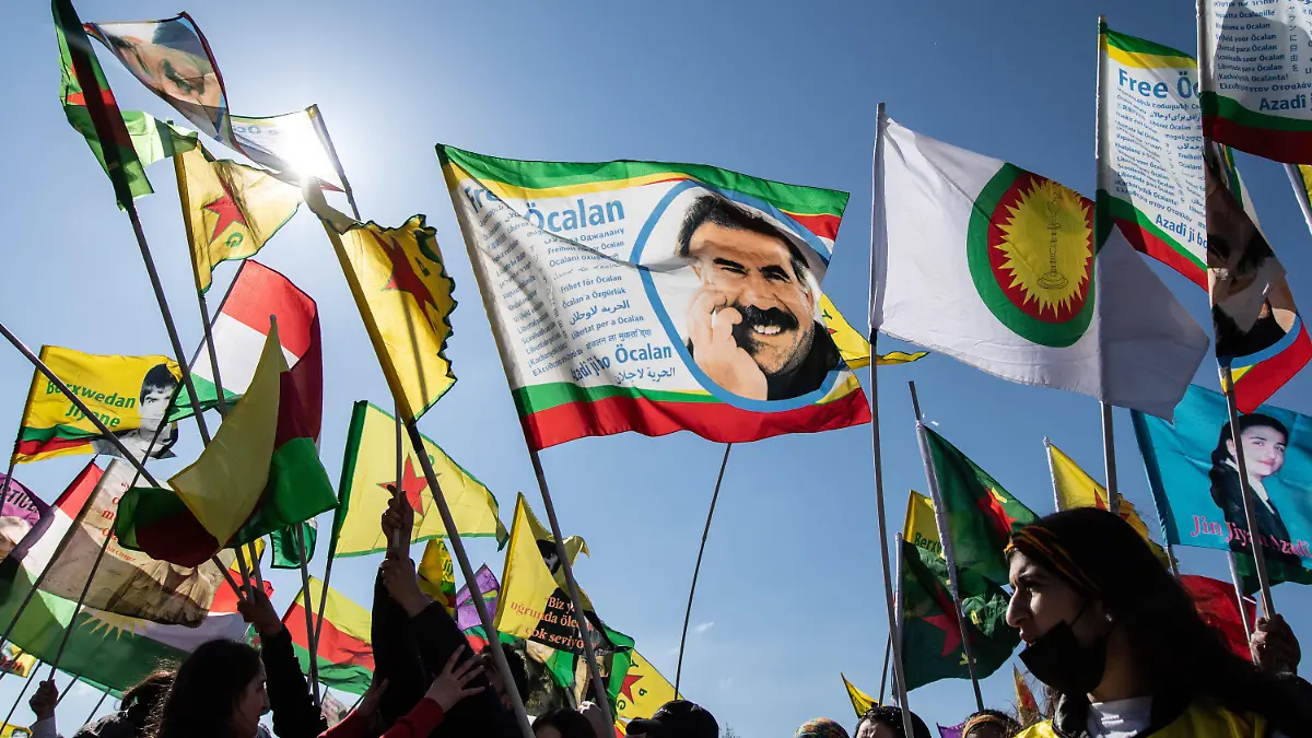 19.03.2022, Hessen, Frankfurt/Main: Ein Mann zeigt auf der kurdischen Newroz-Feier in Frankfurt eine Fahne mit dem Bild des inhaftierten Kurdenführers Abdullah Öcalan. Mehr als zehntausend Kurden aus dem gesamten Bundesgebiet und dem angrenzenden Ausland sind zu der Feier auf einem Freigelände angereist. Foto: Boris Roessler/dpa +++ dpa-Bildfunk +++