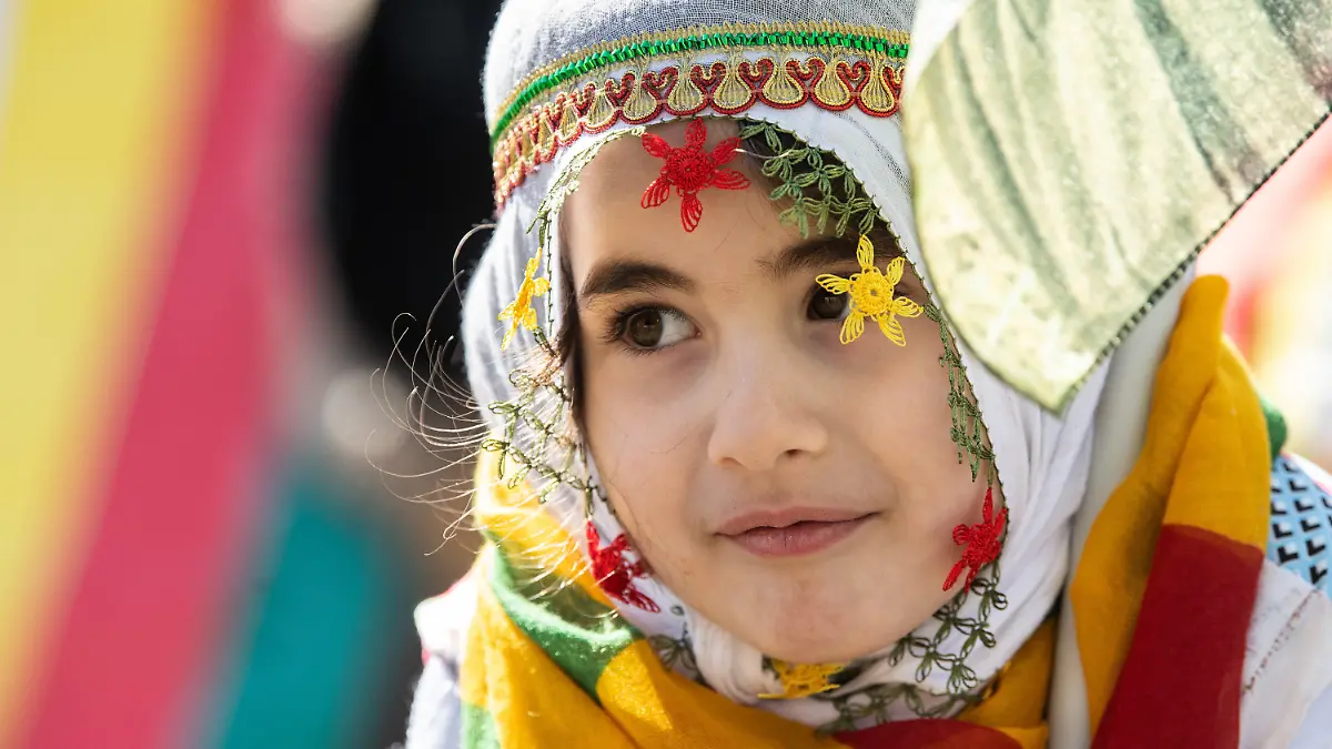 19.03.2022, Hessen, Frankfurt/Main: Ein kleines Mädchen schwenkt auf der zentralen kurdischen Newroz-Feier in Frankfurt eine Fahne. Mehr als zehntausend Kurden aus dem gesamten Bundesgebiet und dem angrenzenden Ausland sind zu der Feier auf einem Freigelände angereist. Foto: Boris Roessler/dpa +++ dpa-Bildfunk +++