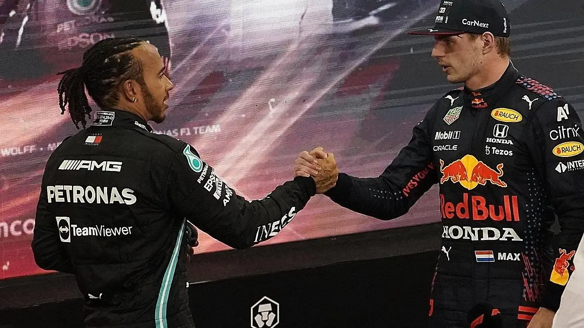 ARCHIV - 12.12.2021, Vereinigte Arabische Emirate, Abu Dhabi: Motorsport: Formel-1-Weltmeisterschaft, Grand Prix von Abu Dhabi, Rennen. Lewis Hamilton (l) aus Großbritannien vom Team Mercedes gratuliert Max Verstappen aus den Niederlanden vom Team Red Bull zum Weltmeistertitel. Verstappen hat zum ersten Mal den Fahrertitel in der Formel 1 geholt und Rekordweltmeister Hamilton entthront. (zu dpa «Das muss man zum Formel-1-Auftakt von Bahrain wissen») Foto: Hasan Bratic/dpa +++ dpa-Bildfunk +++