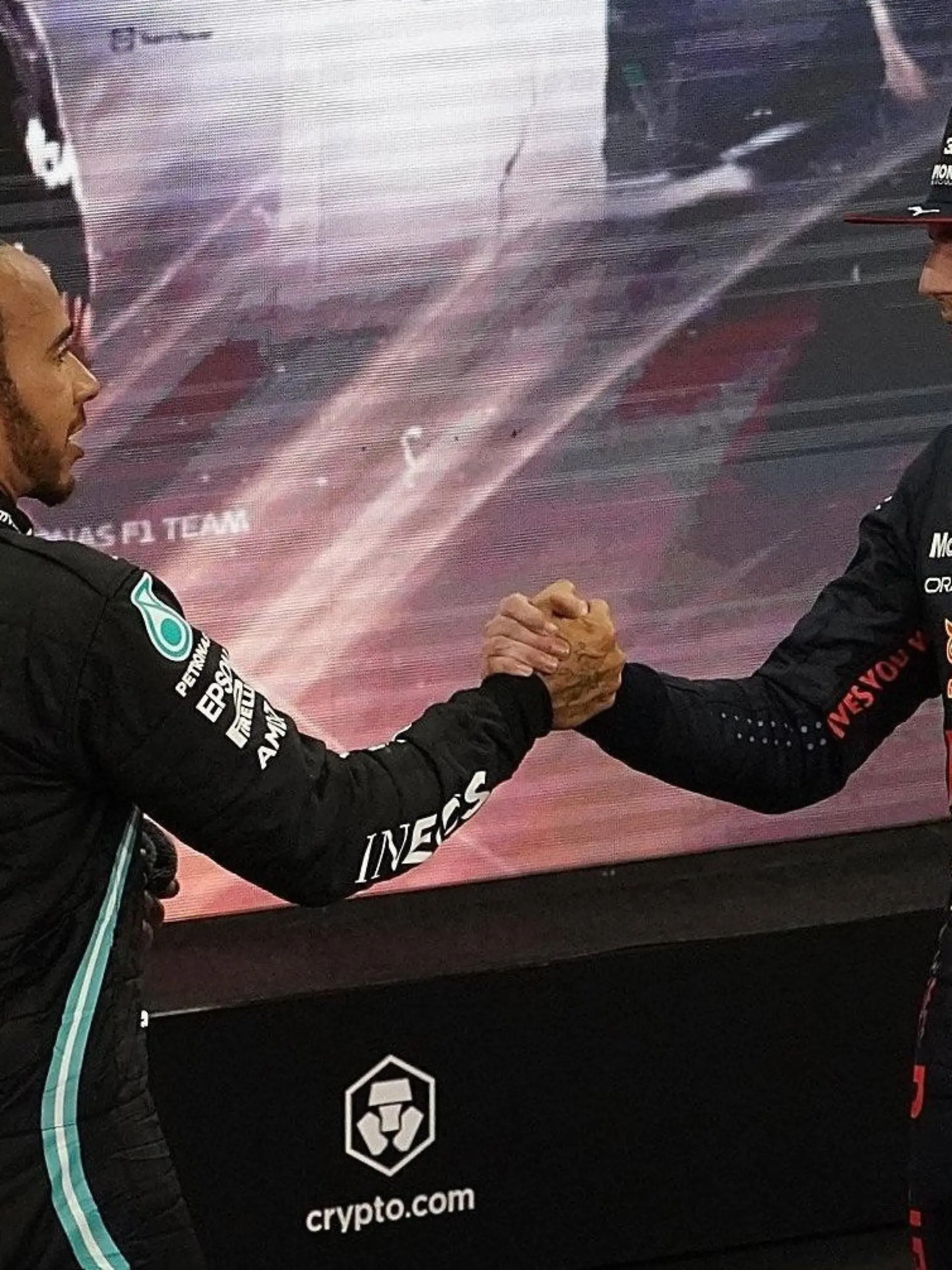 ARCHIV - 12.12.2021, Vereinigte Arabische Emirate, Abu Dhabi: Motorsport: Formel-1-Weltmeisterschaft, Grand Prix von Abu Dhabi, Rennen. Lewis Hamilton (l) aus Großbritannien vom Team Mercedes gratuliert Max Verstappen aus den Niederlanden vom Team Red Bull zum Weltmeistertitel. Verstappen hat zum ersten Mal den Fahrertitel in der Formel 1 geholt und Rekordweltmeister Hamilton entthront. (zu dpa «Das muss man zum Formel-1-Auftakt von Bahrain wissen») Foto: Hasan Bratic/dpa +++ dpa-Bildfunk +++